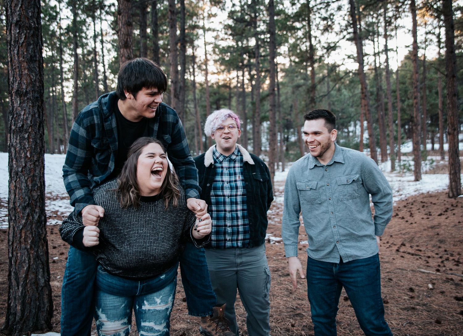 Siblings laughing together during winter outdoor family photo session at Fox Run Park in Colorado Springs