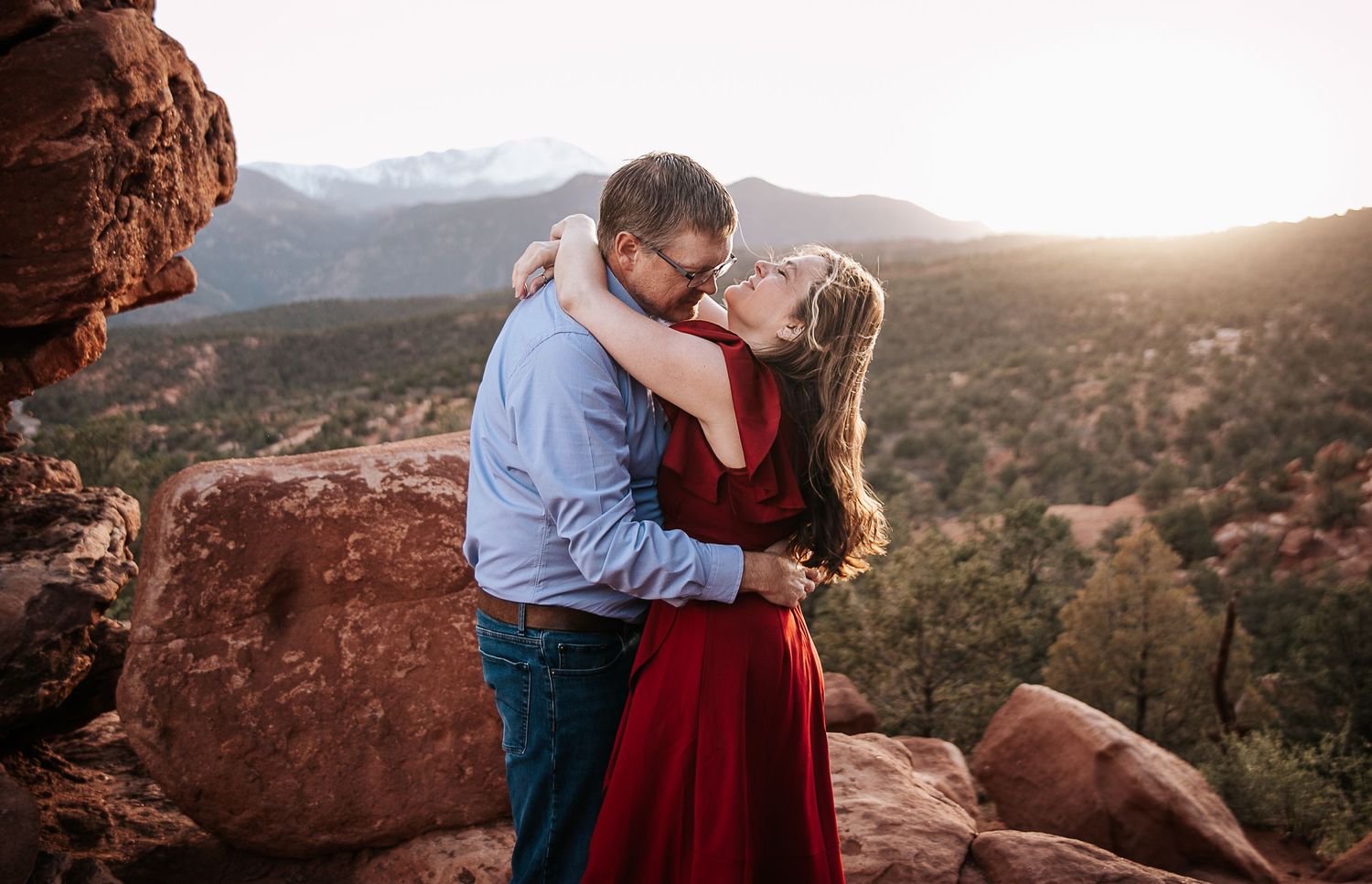 Romantic embrace captured against stunning red rock formations at sunset.