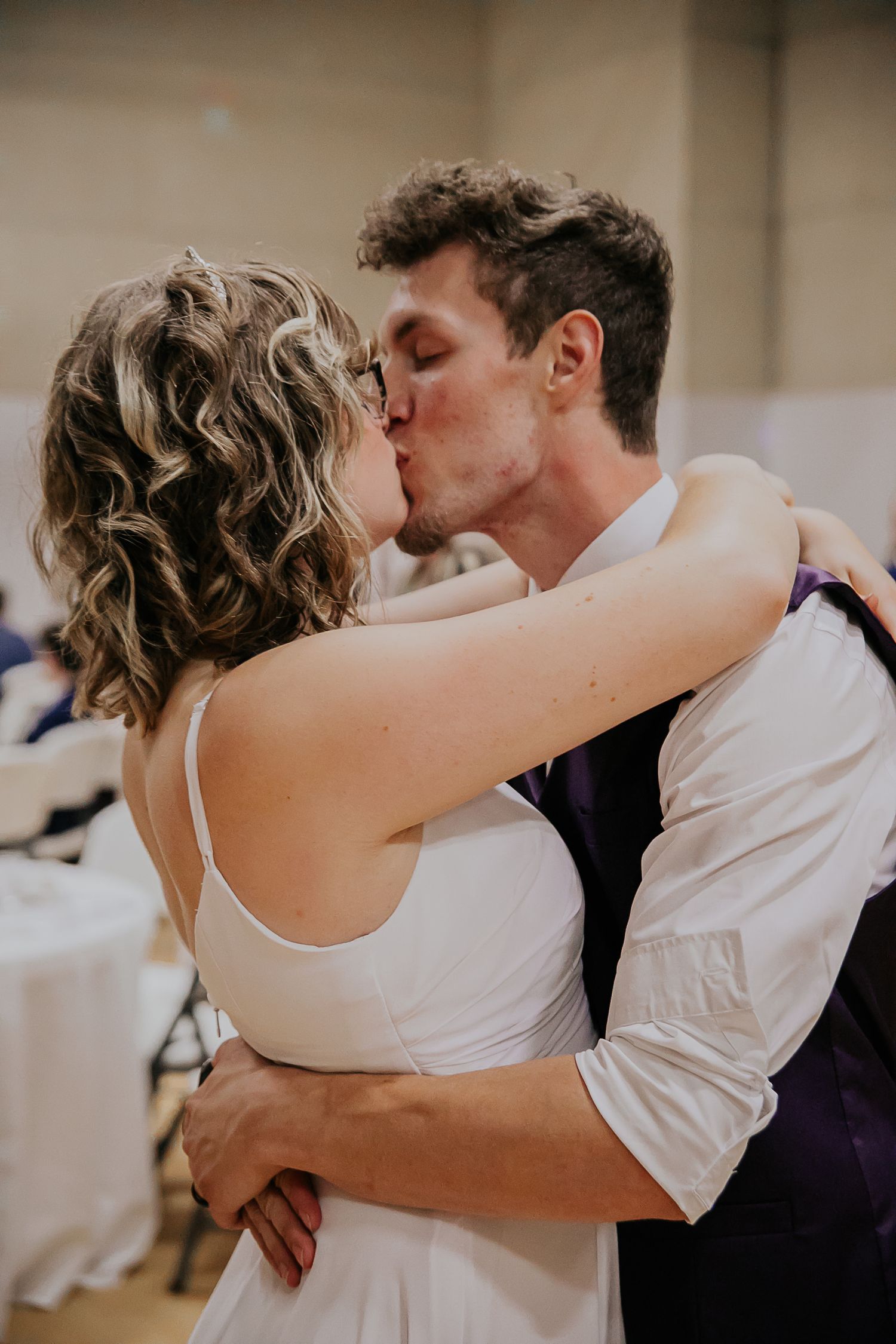 A romantic kiss between newlyweds during their wedding reception dance.