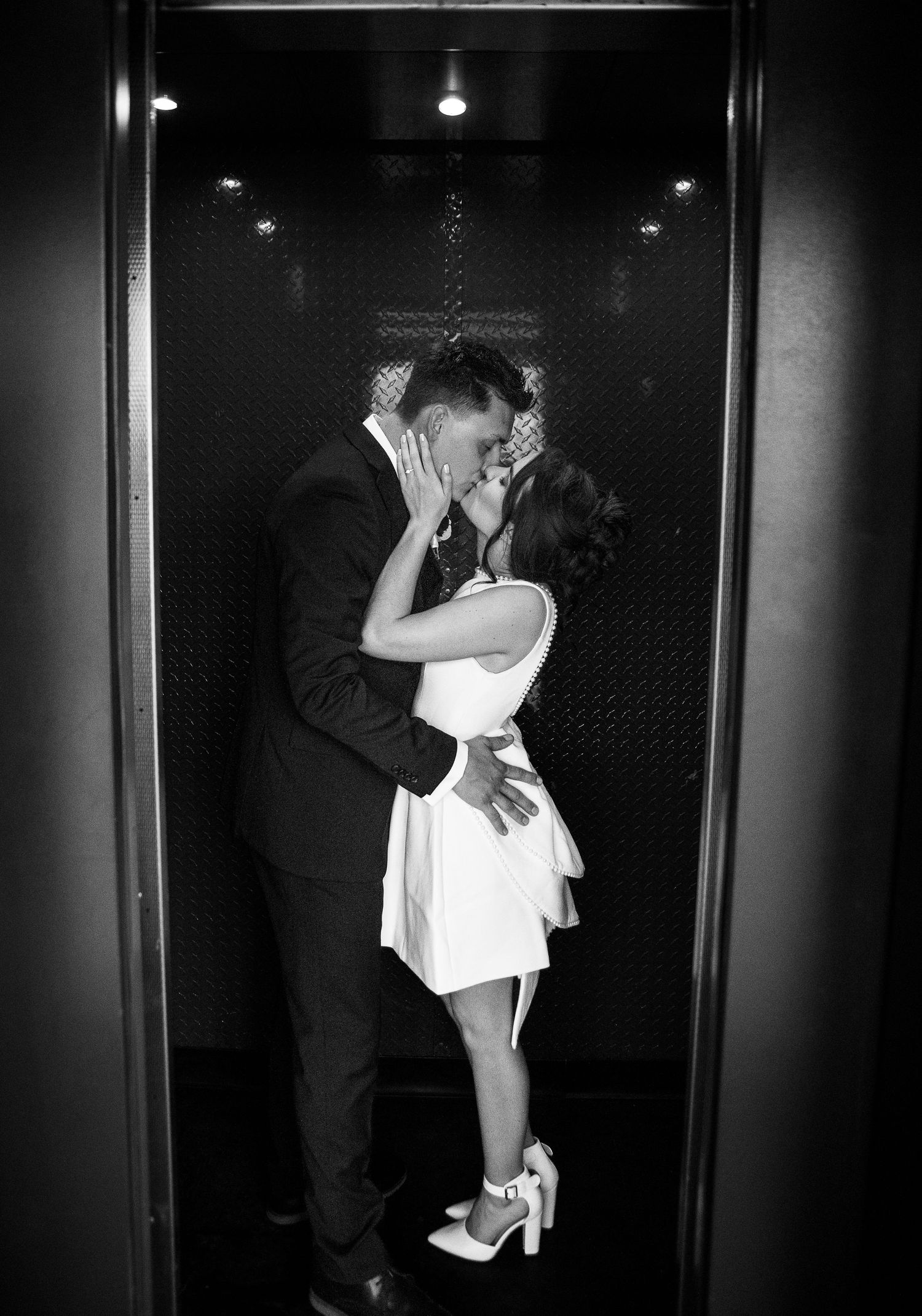 Black and white photo sequence showing a romantic elevator kiss between a couple in formal attire.