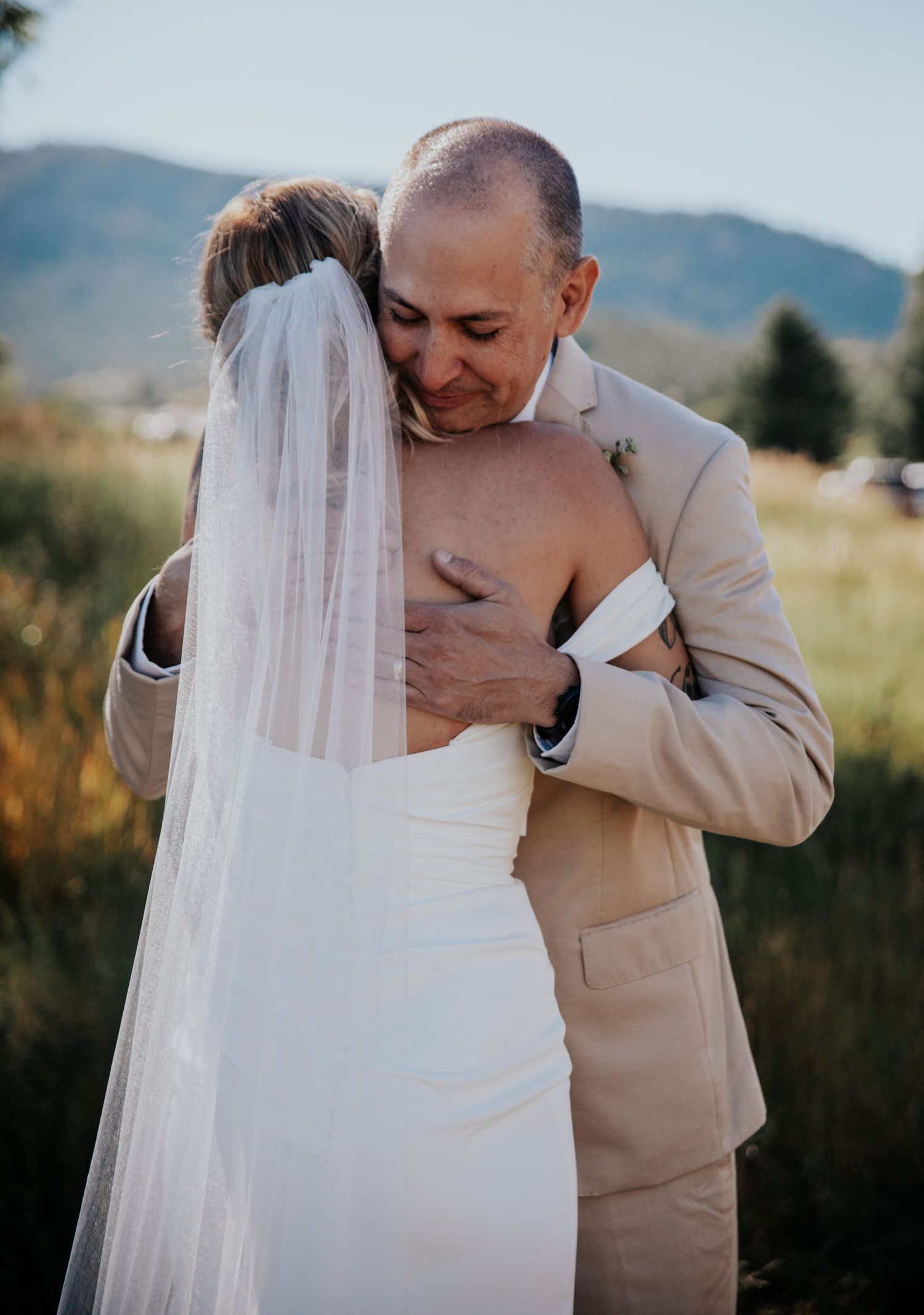 An emotional embrace captured during a scenic outdoor wedding ceremony.