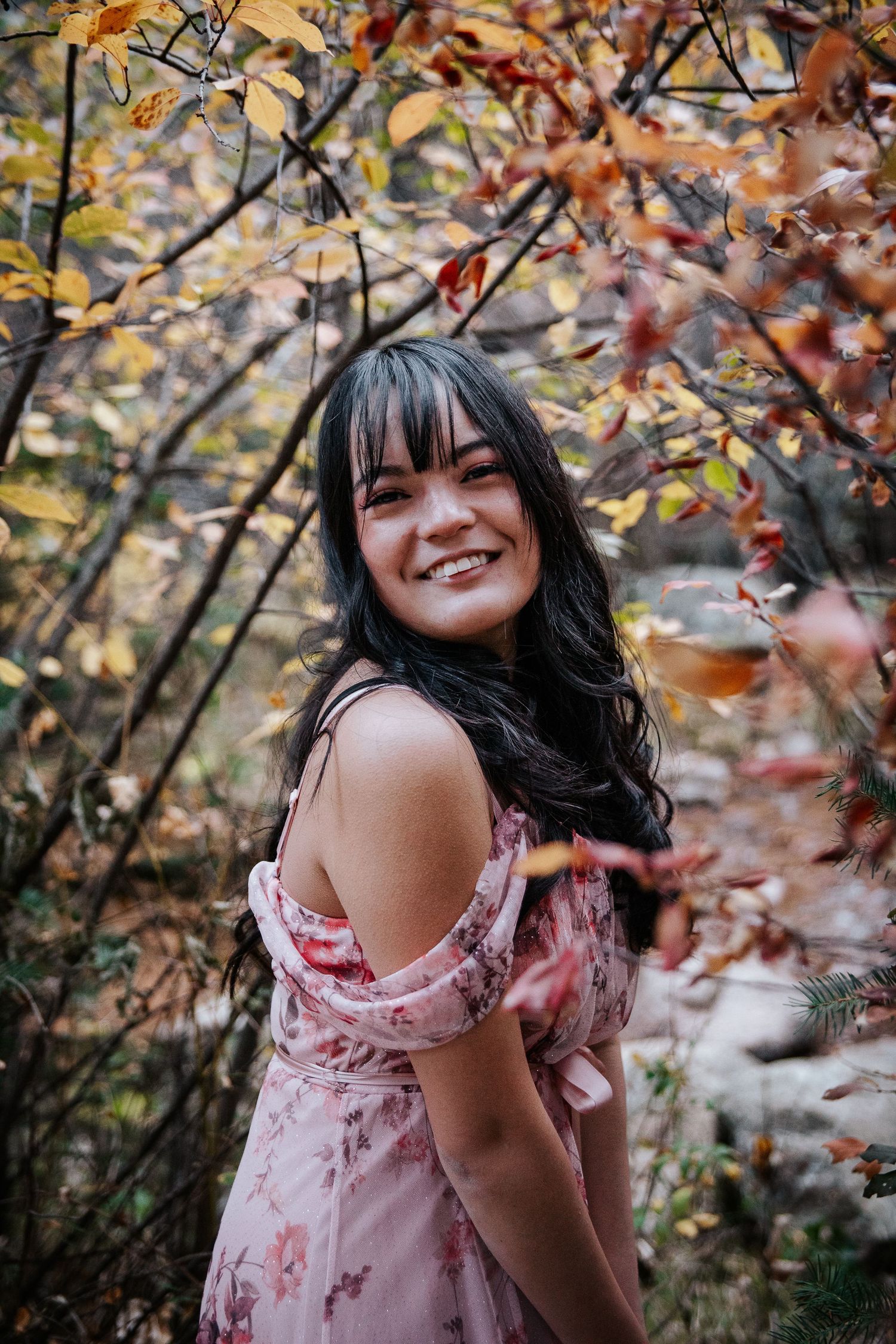 A joyful autumn portrait with colorful fall foliage in the background.