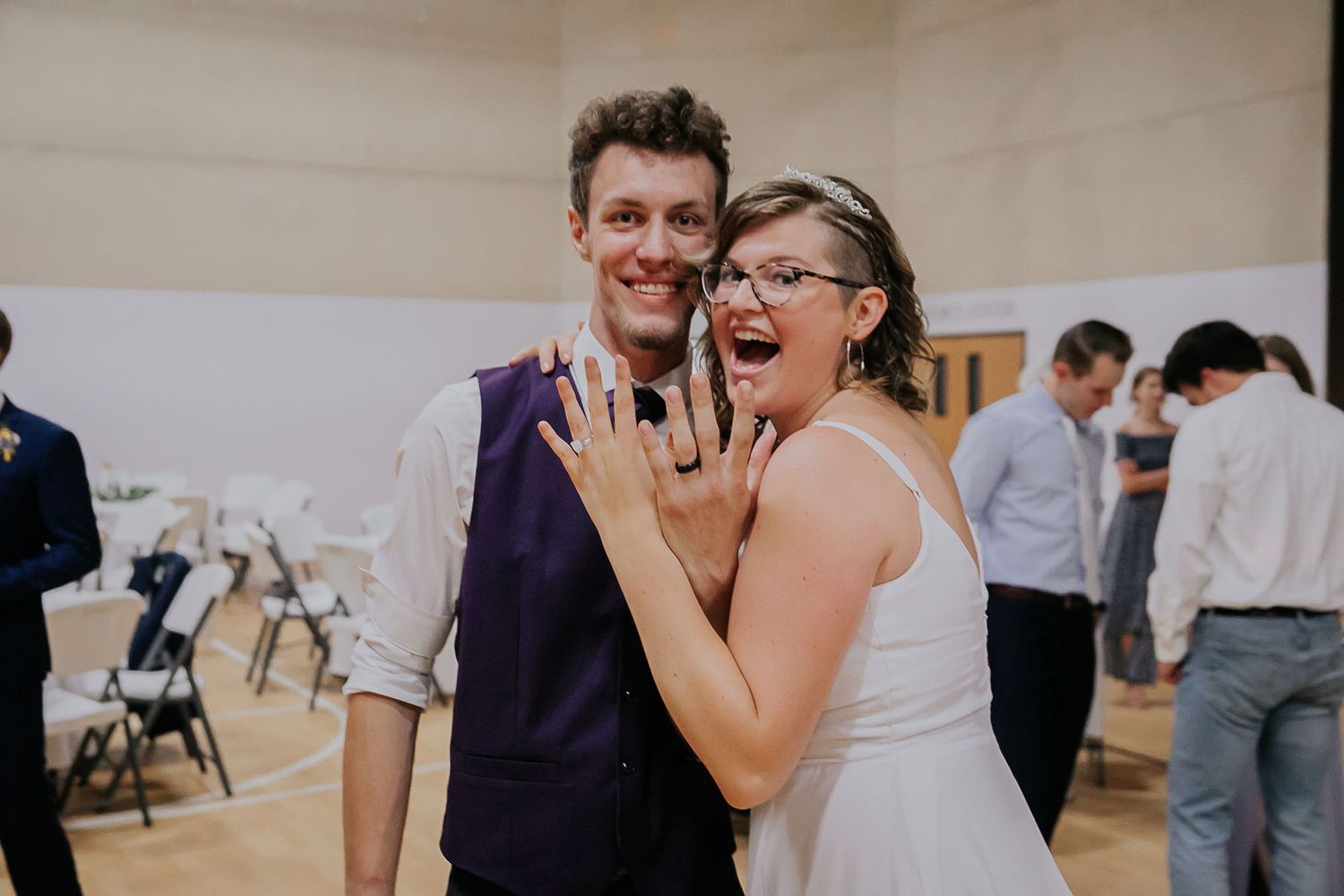 People sharing joyful moments and laughter during a celebration in an indoor venue.