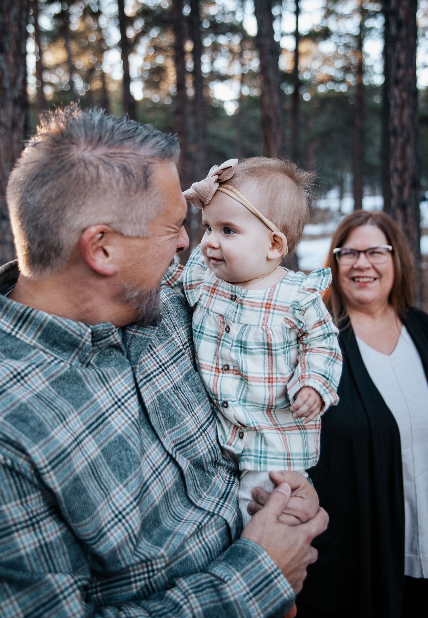 Heartwarming interaction between generations captured in a winter forest setting.