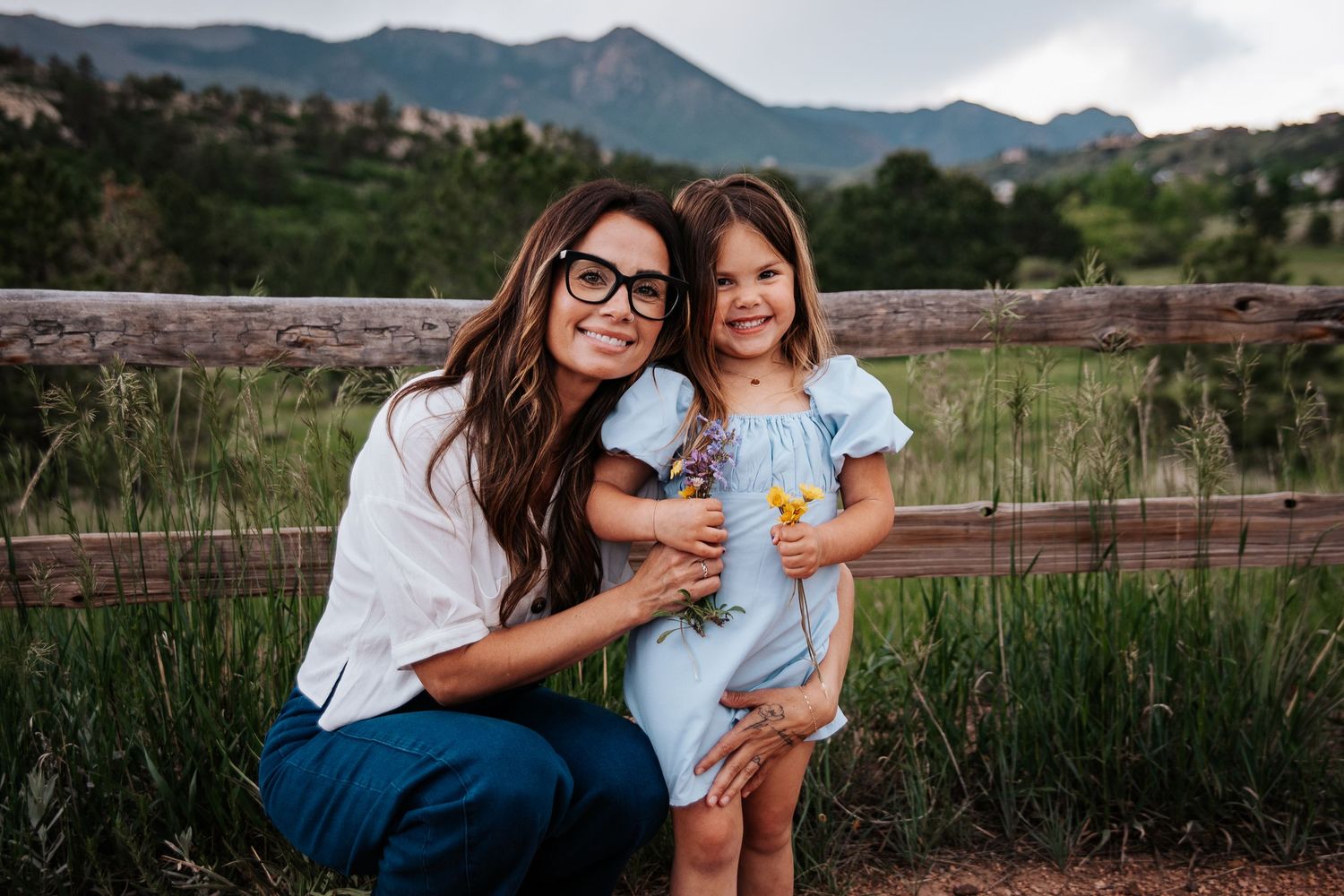 Mother and daughter in coordinated blue and white outfits pose by mountain vista at Ute Valley Park in Colorado Springs