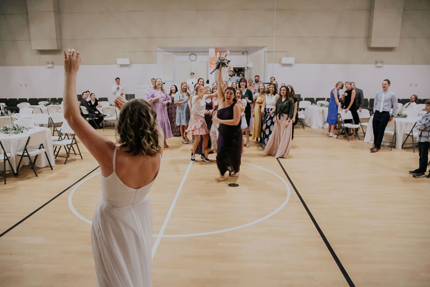 People with raised arms celebrating during a festive indoor gathering.