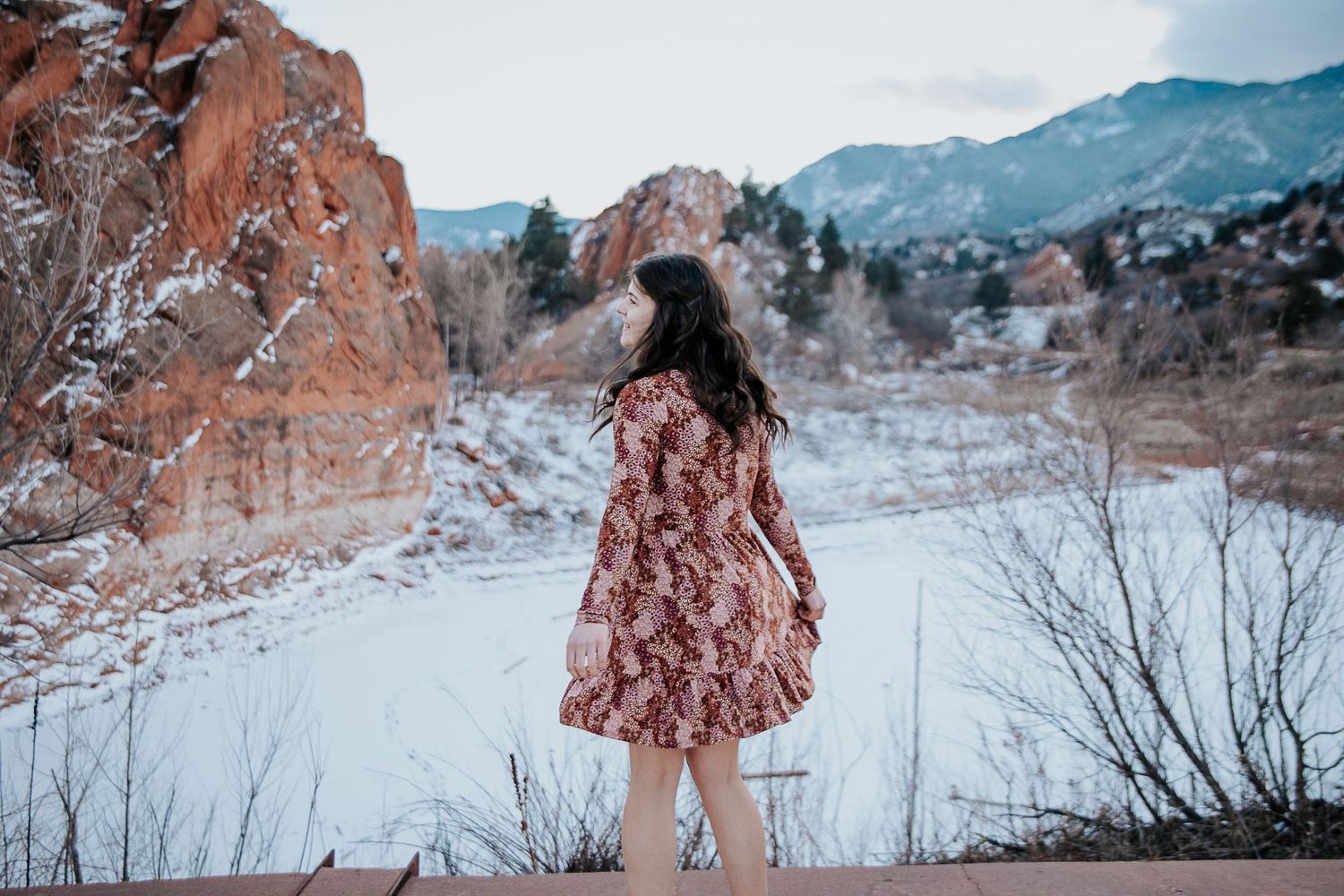 Artistic winter photography featuring floral fashion against mountain backdrop.
