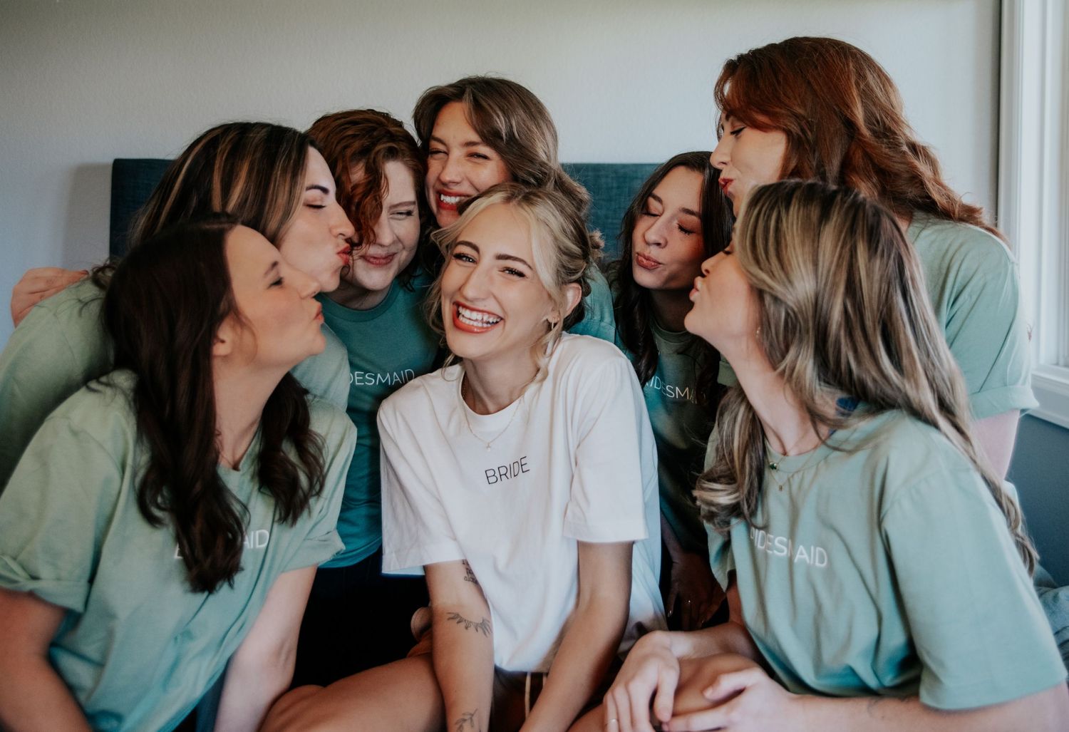 Bridal party in matching mint green shirts gathered for a fun group photo.