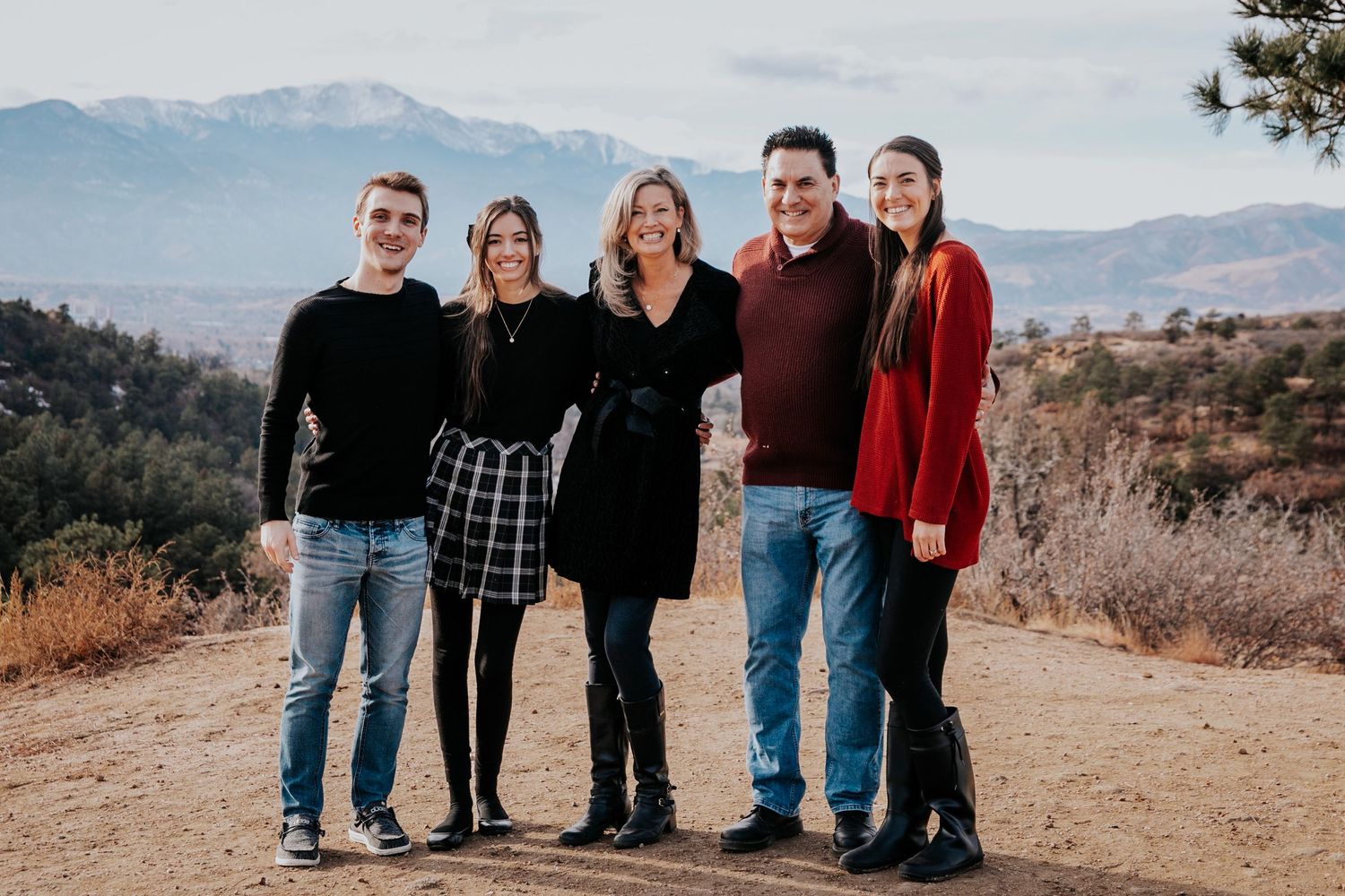 Group photo session of family members on a mountain trail during golden hour.
