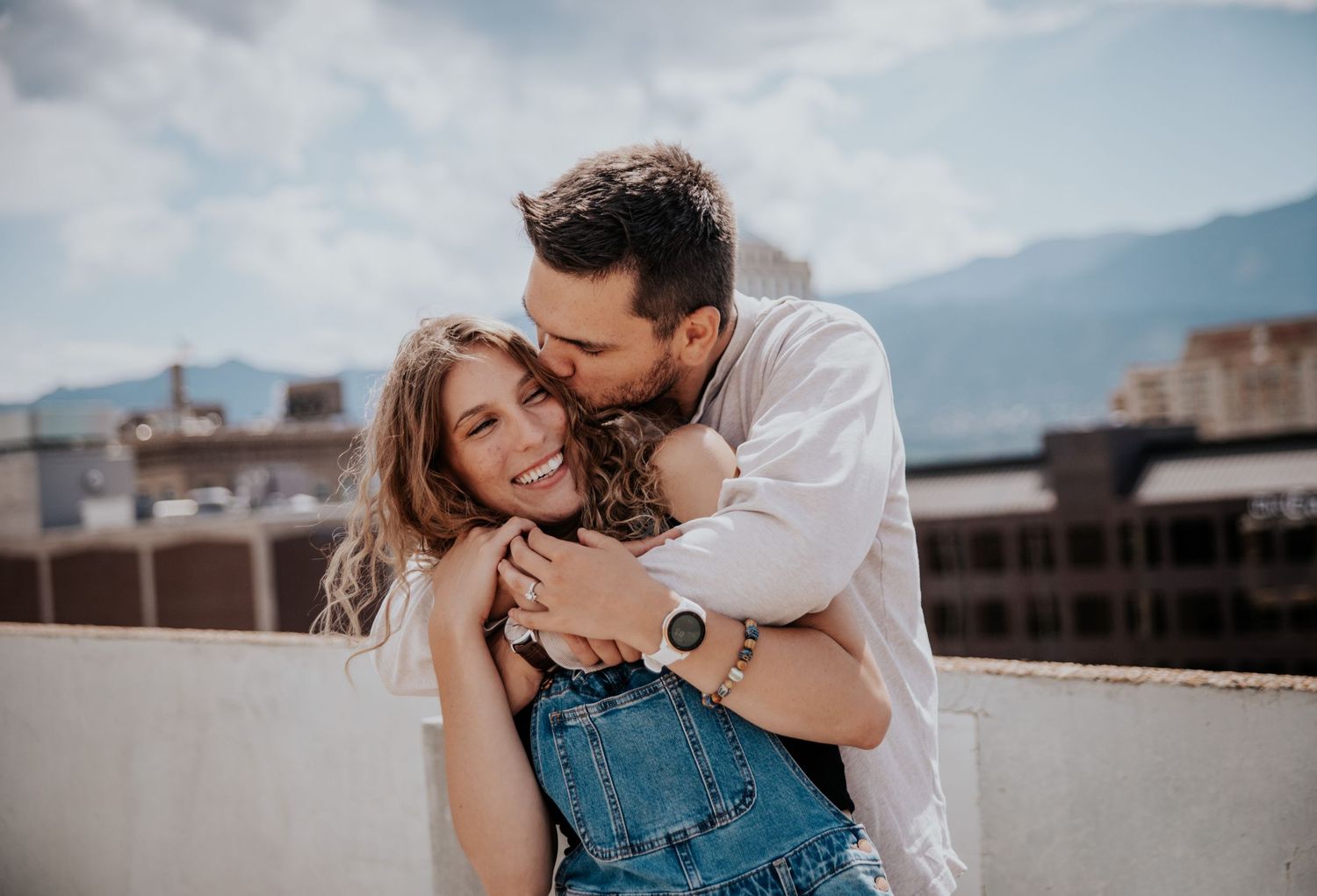 Romantic rooftop photoshoot with city mountains in background.