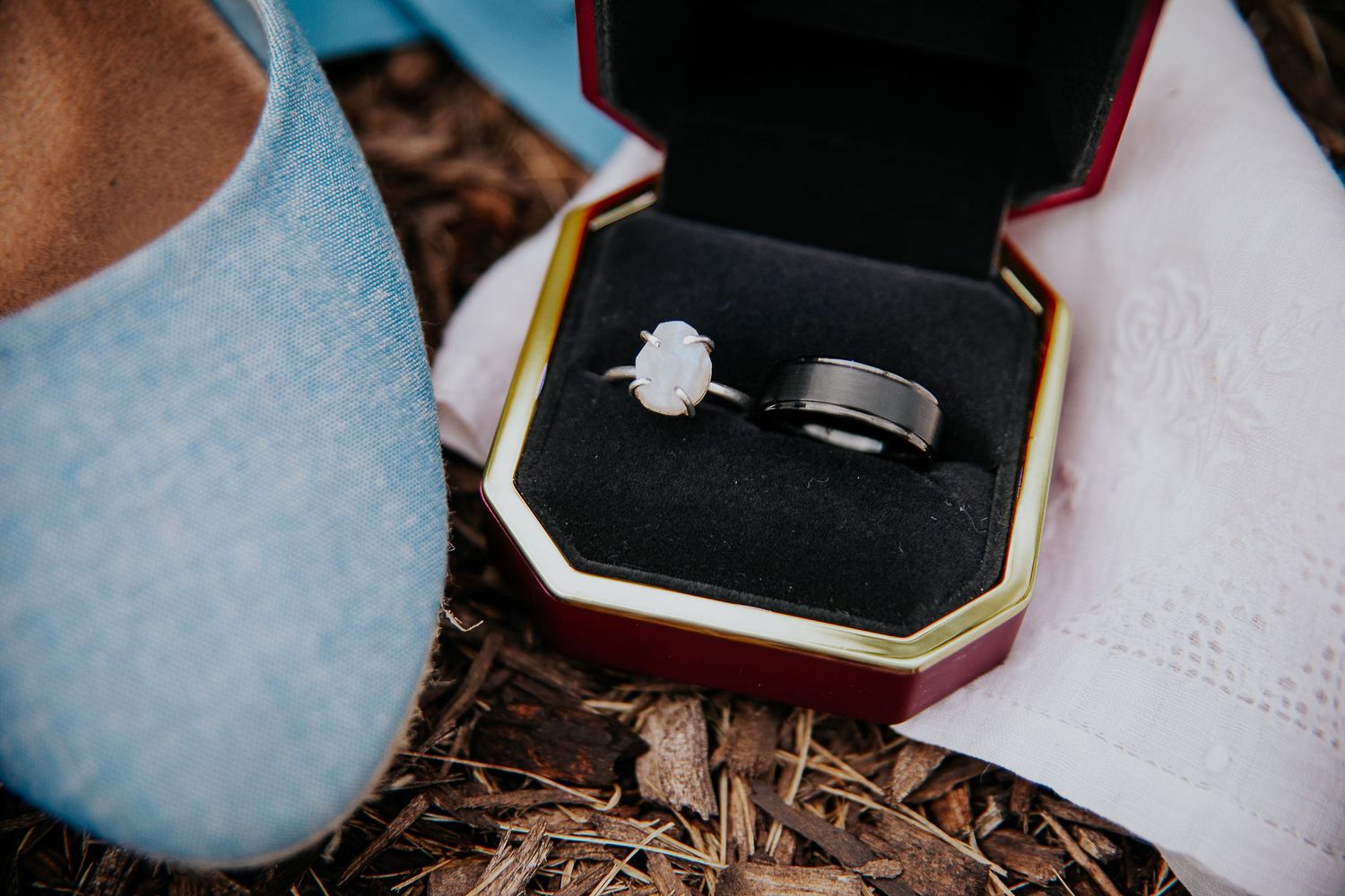 Close-up details of pale blue wedding flats with small bows on rustic ground.