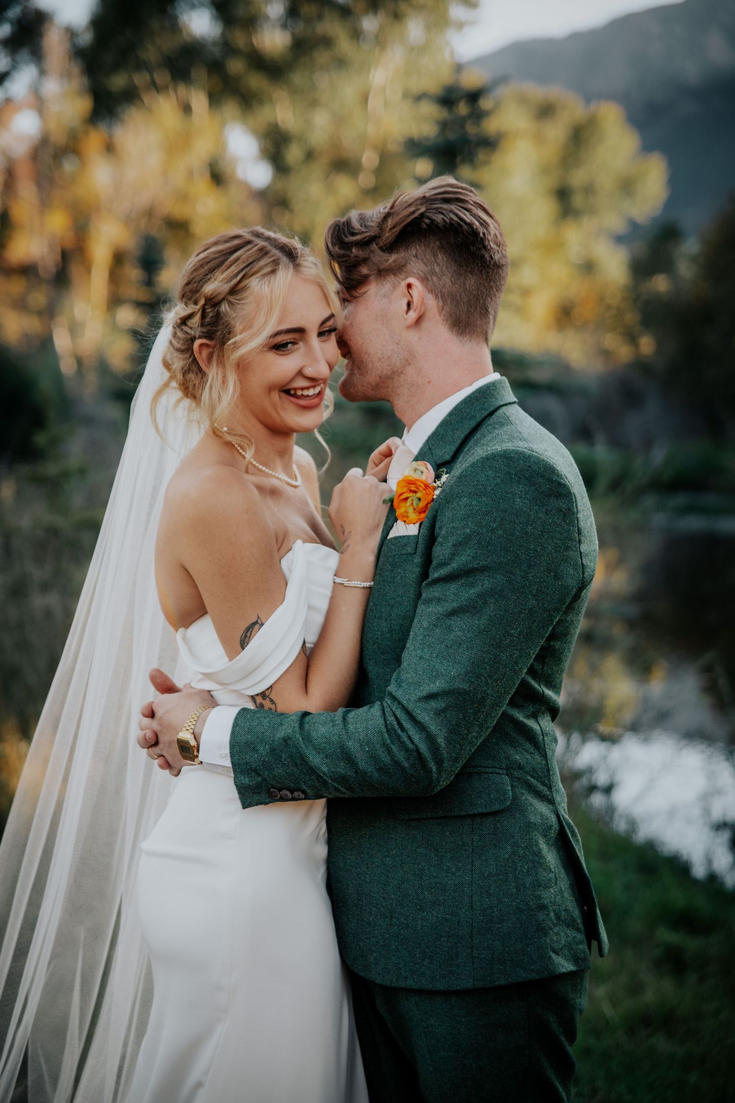 Joyful wedding moment captured against mountain landscape with autumn colors.