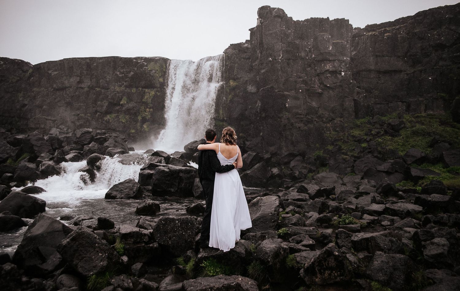 Bride and groom at waterfall in Öxarárfoss in Iceland during elopement shoot