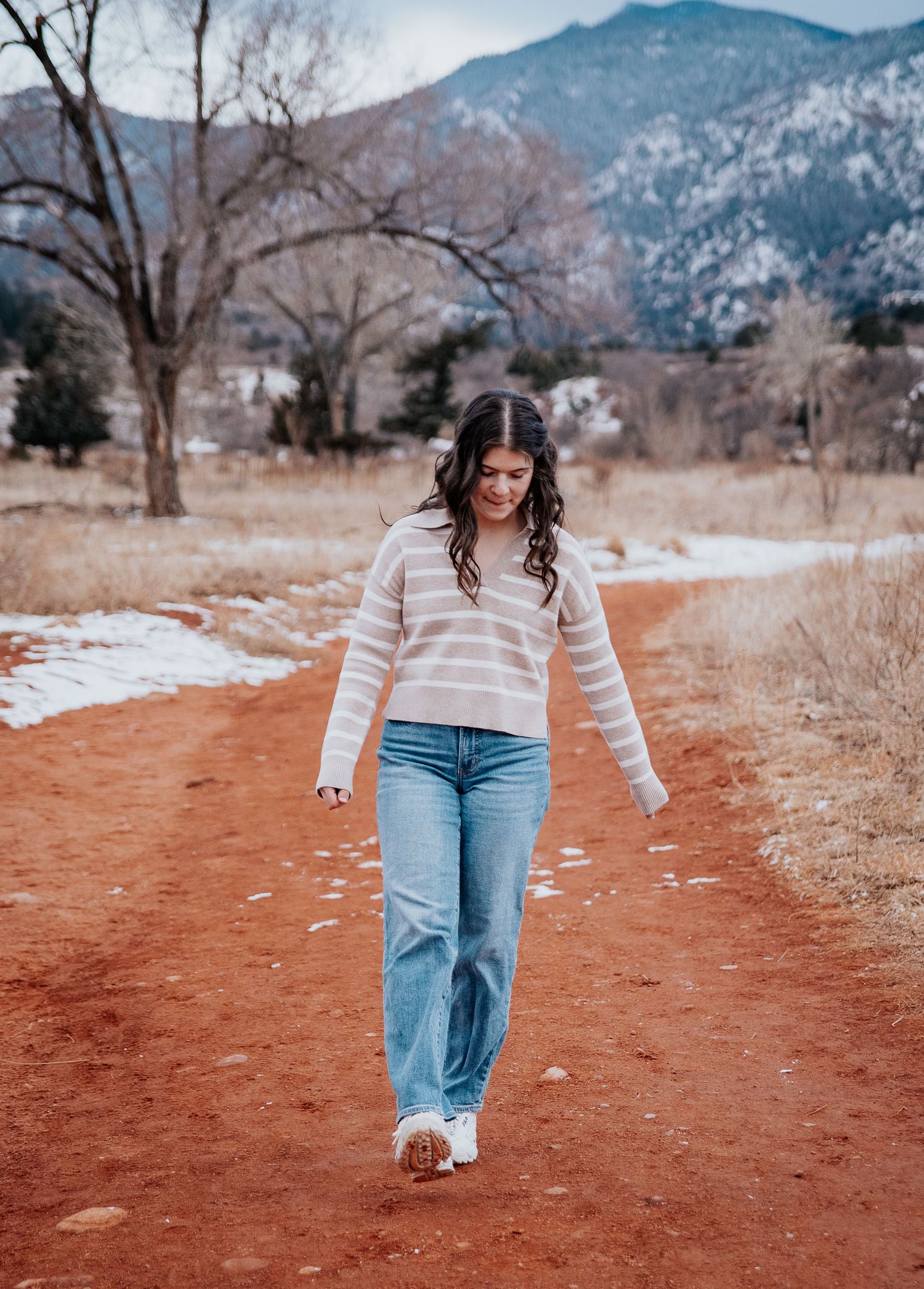 Walking session on a red dirt path with snow-capped mountains in the background.