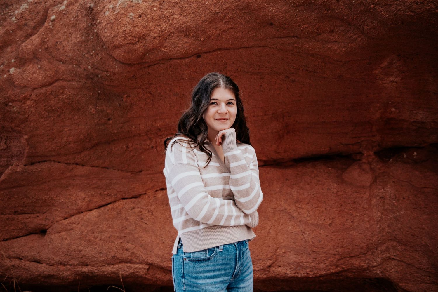 Portrait session against striking red rock formations in an outdoor setting.