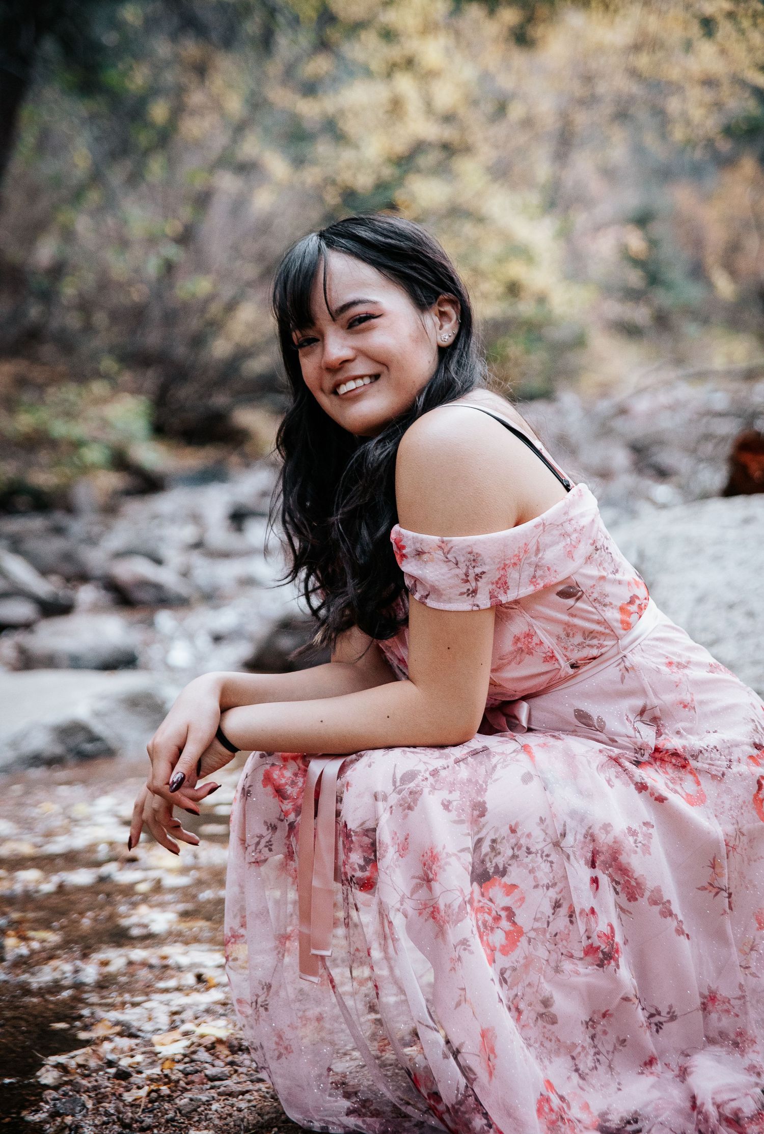 A dreamy autumn portrait session featuring a pink floral dress among fallen leaves.