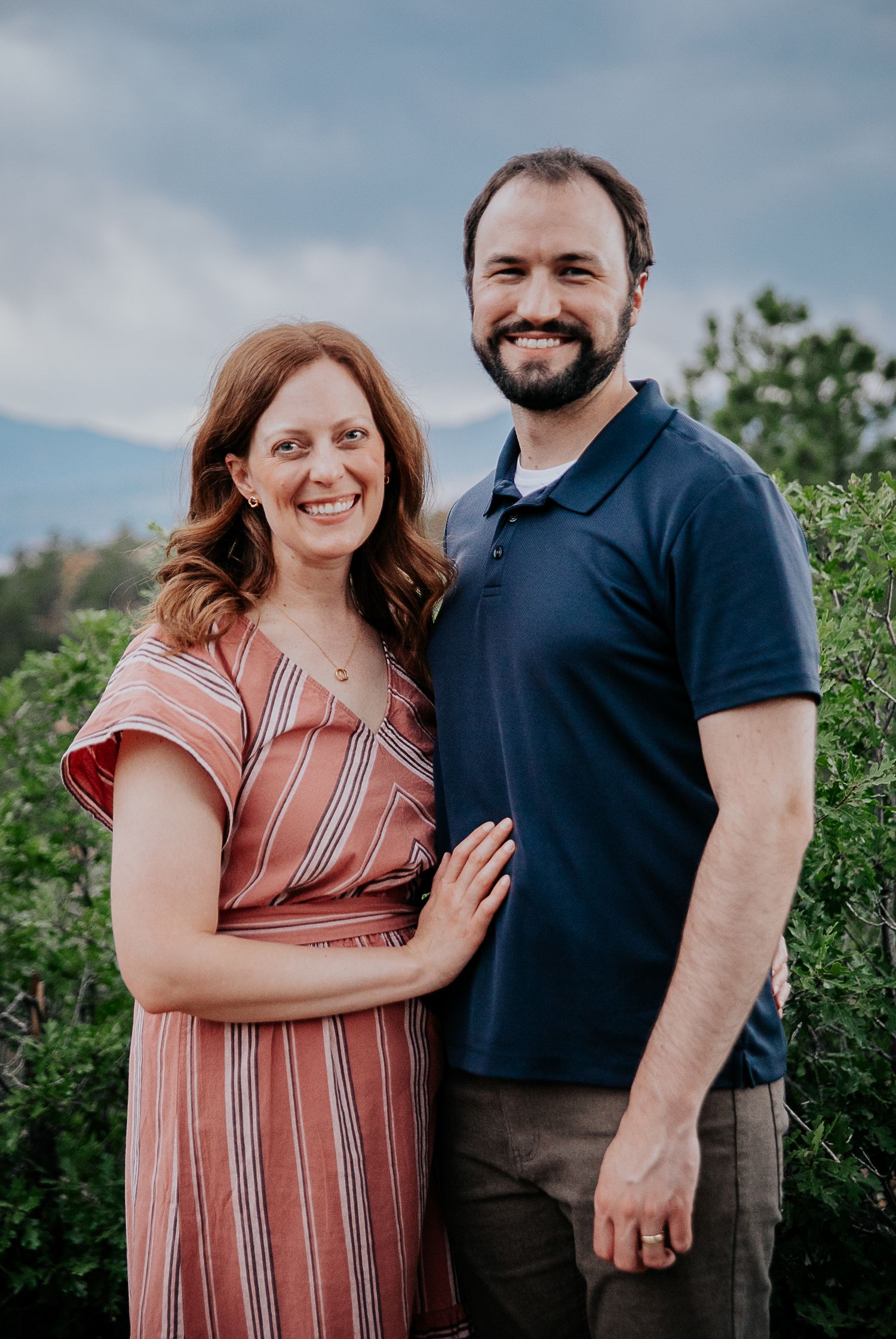 A couple shares loving glances while posing for photos in nature.