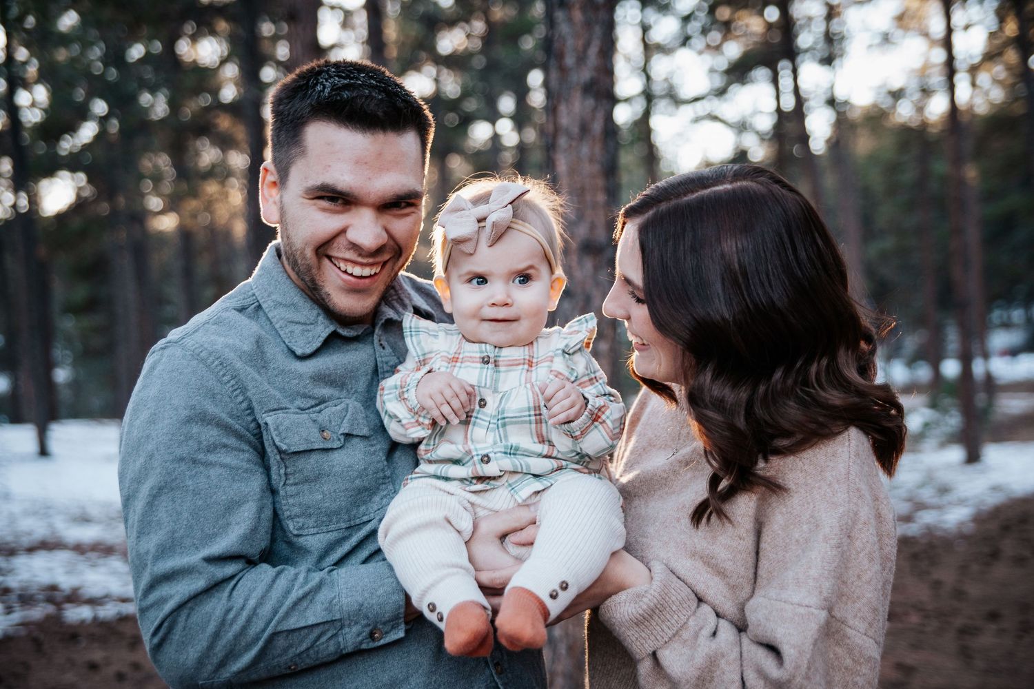 A loving family shares tender moments together in a winter forest scene.