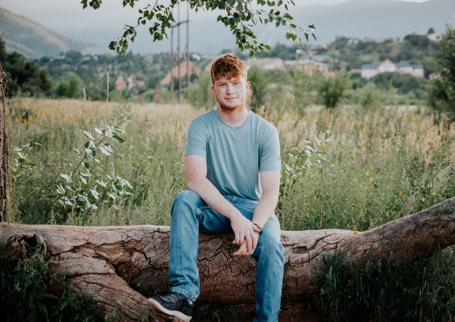 Casual outdoor portraits taken in a natural setting with mountains and greenery.