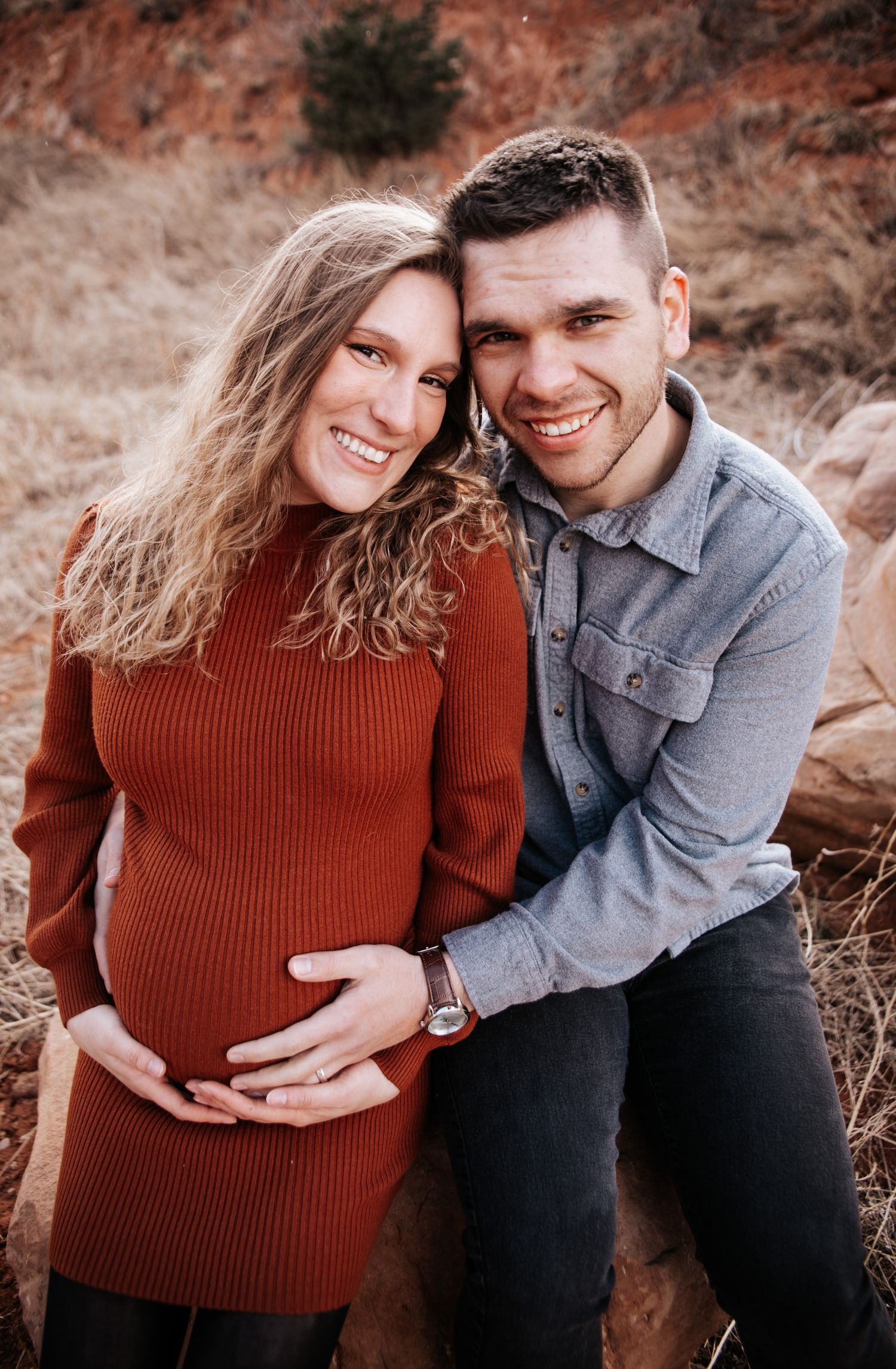 Couple leaning into each other during outdoor winter maternity photo session at Red Rock Canyon Open Space in Colorado Springs