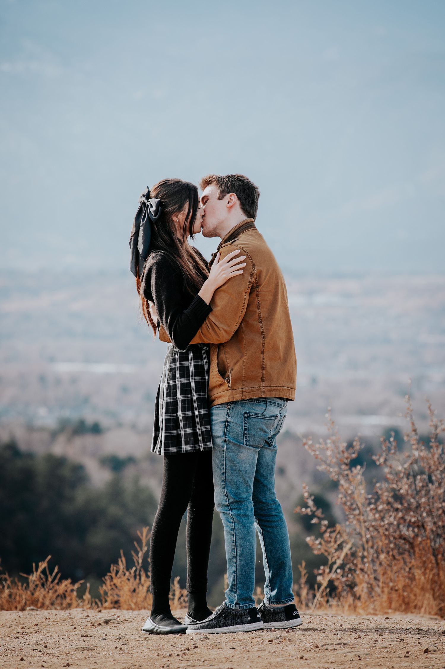 Romantic kiss shared between couple on mountain overlook in Colorado Springs.