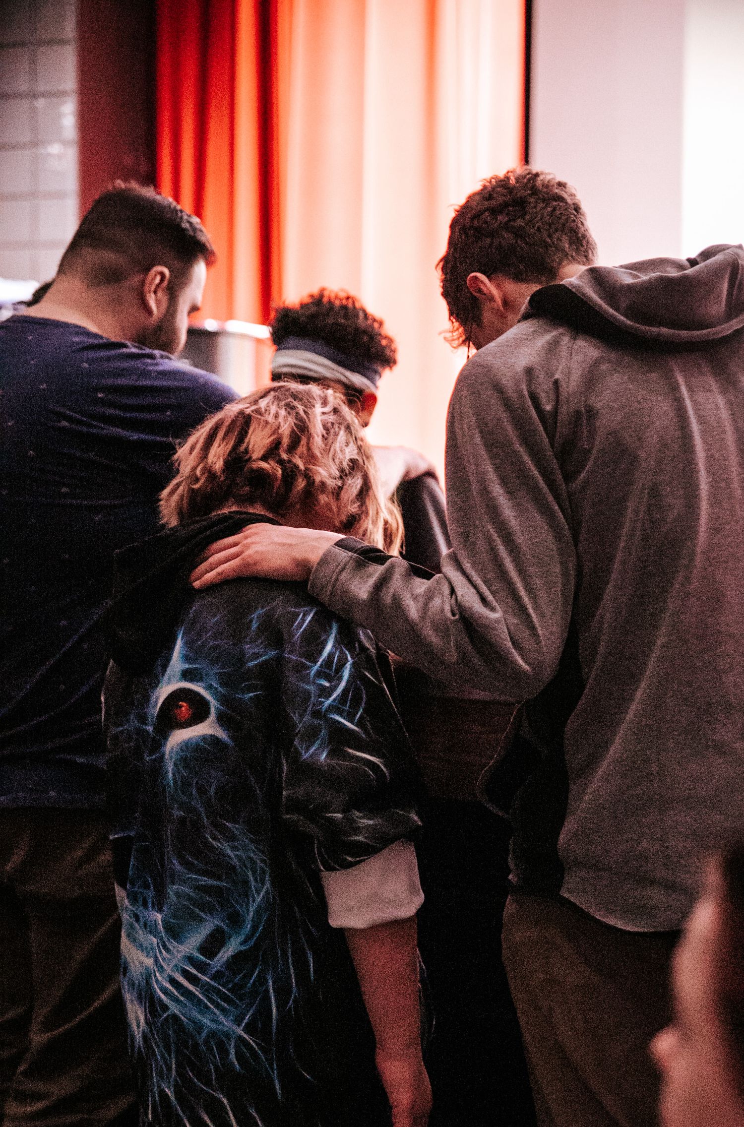 People embracing in a line during an emotional moment of a performance.