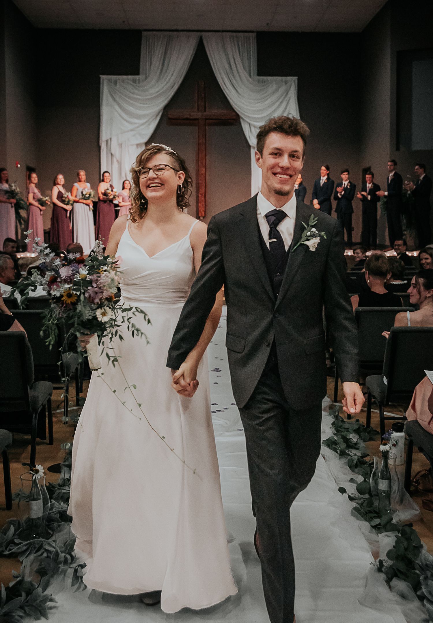 Bride and groom walking down the aisle together after their ceremony, from Colorado Springs wedding photographer Jasmine Morse