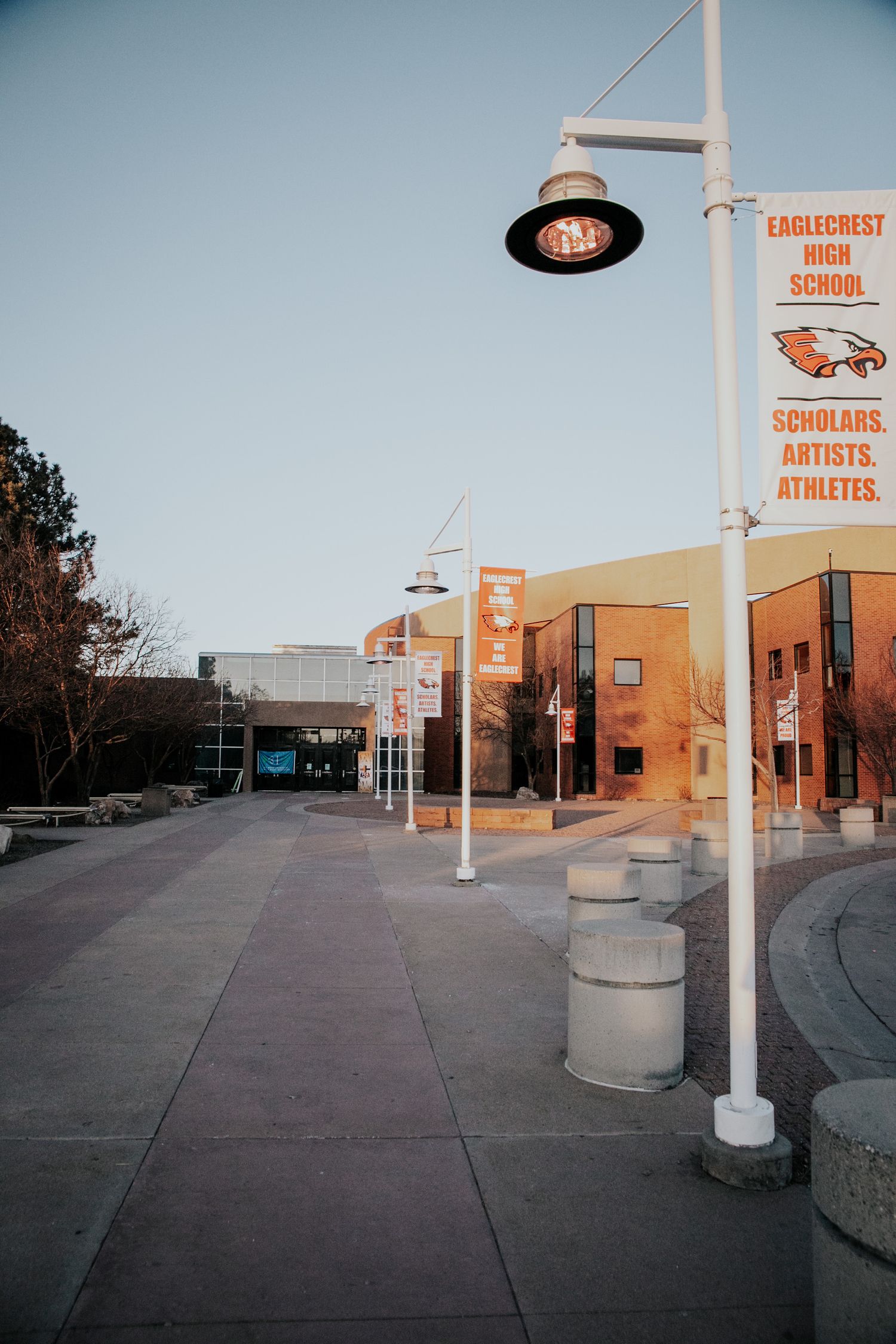 Street view of Eaglecrest High School with lamp posts and signage against a blue sky.