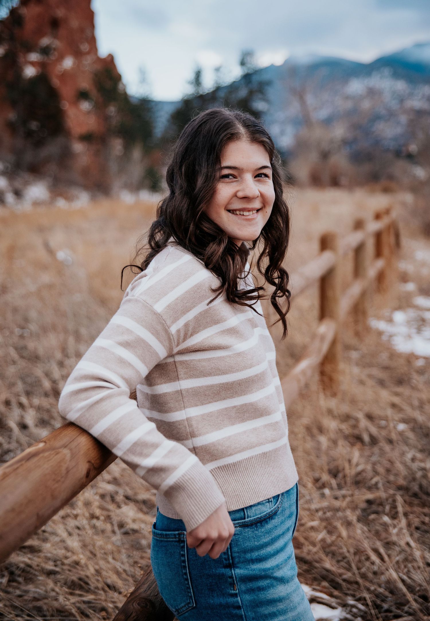 A photoshoot in a mountain landscape featuring casual winter attire and natural scenery.