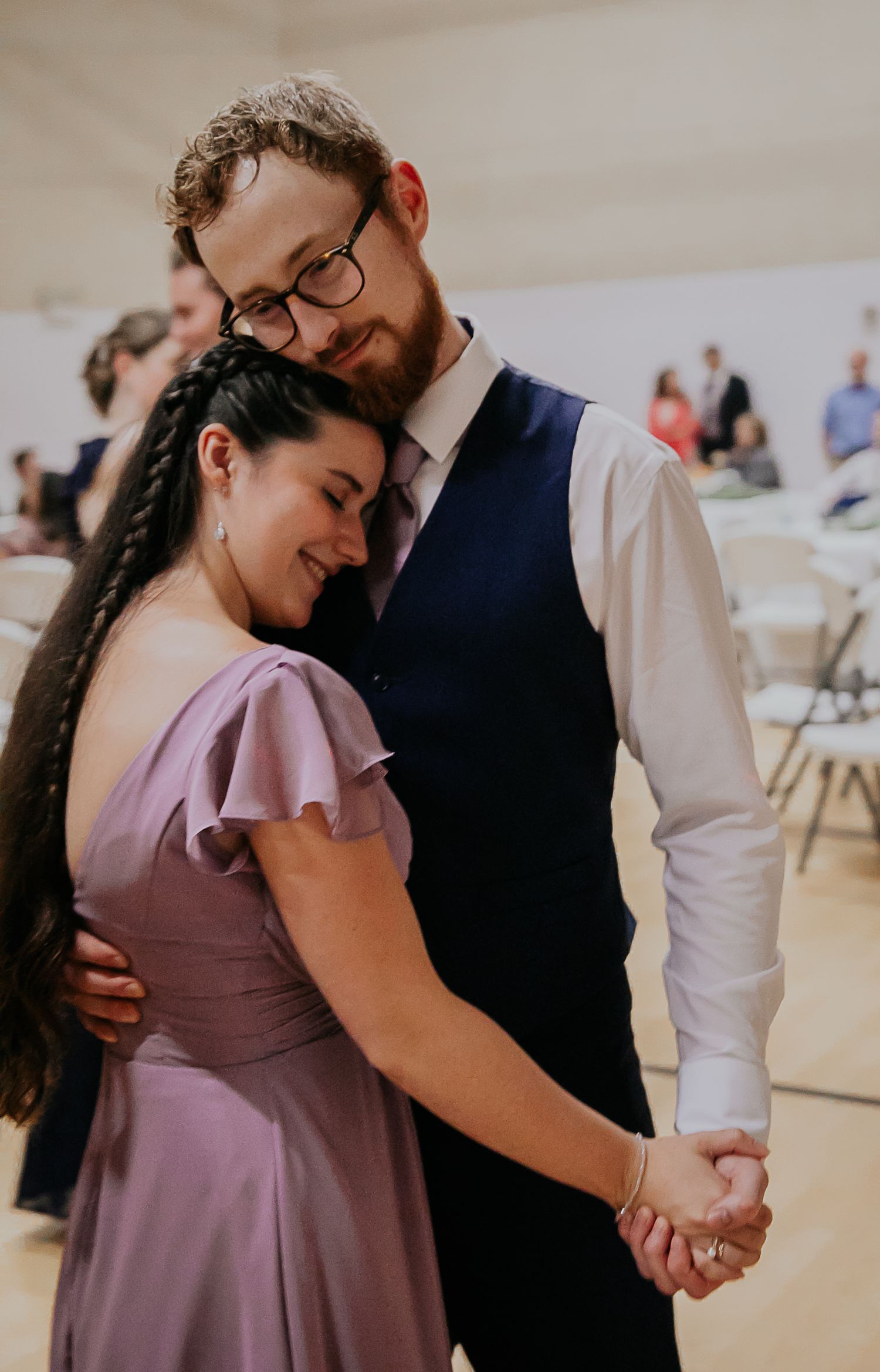 A couple shares an intimate slow dance moment as they embrace on the dance floor.