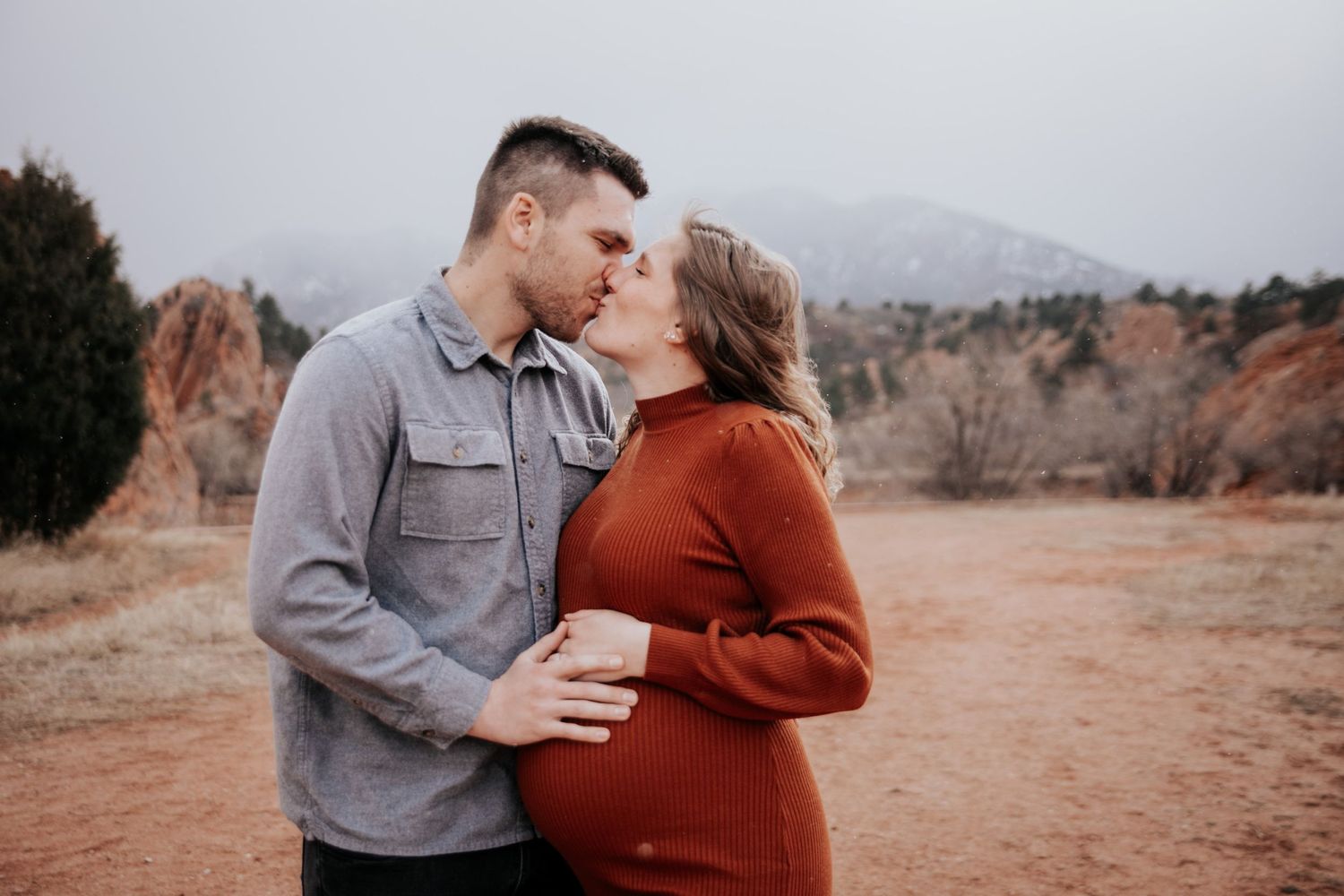 A couple shares an intimate moment during their maternity photoshoot at Garden of the Gods.