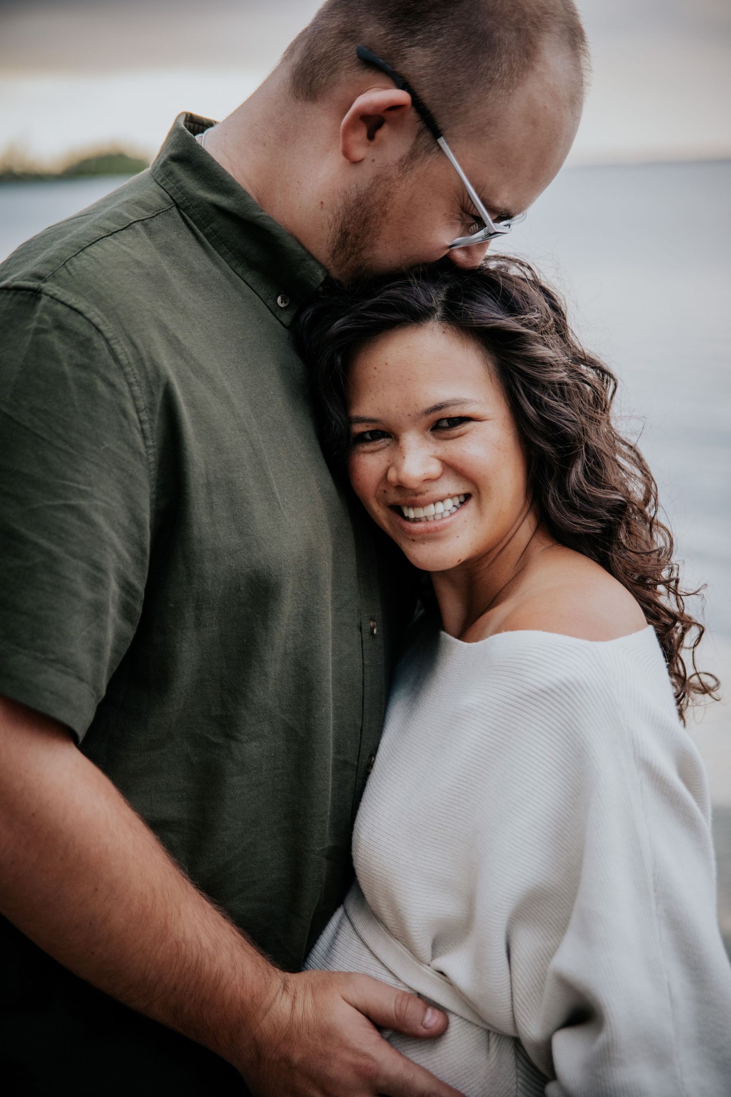 Husband kissing wife's head during maternity photo session in Colorado Springs