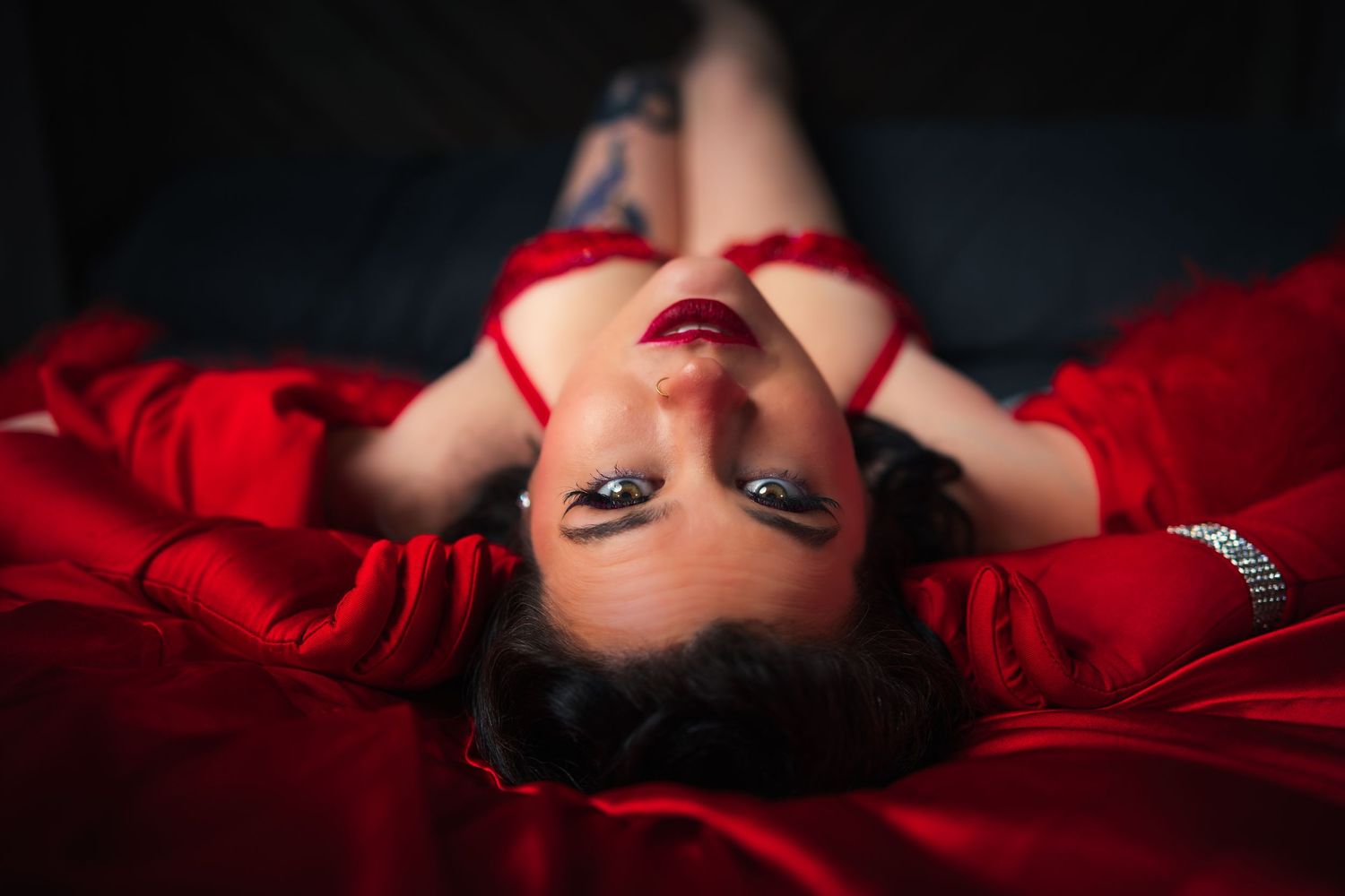 Sensual portrait series with red fabric and dramatic lighting.