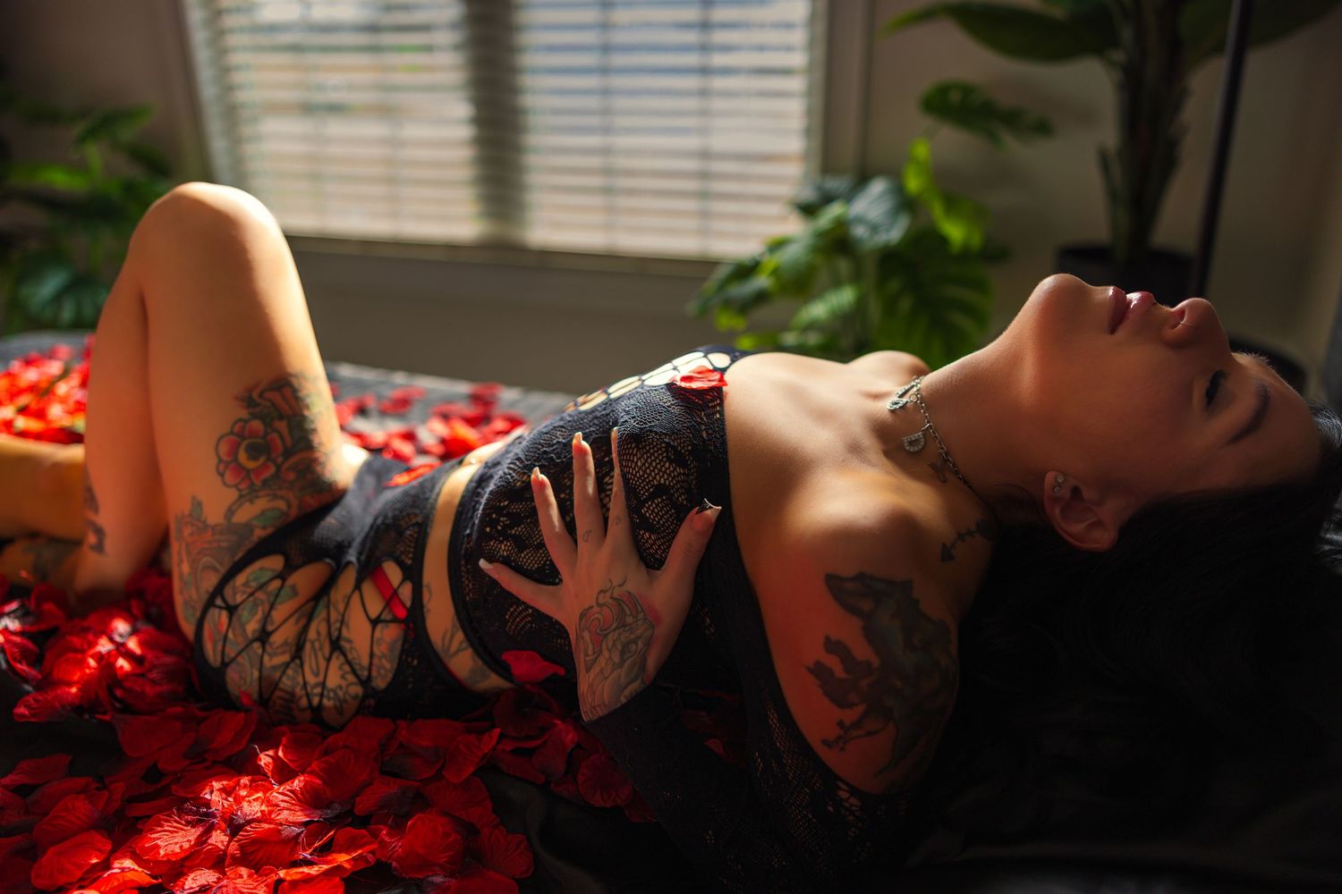 A series of four intimate boudoir photos showing silhouetted figures against window light with red rose petals.