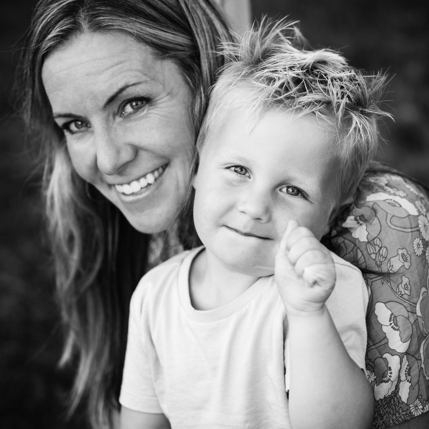 Black and white portrait series showing tender moments between a parent and child in casual white clothing.