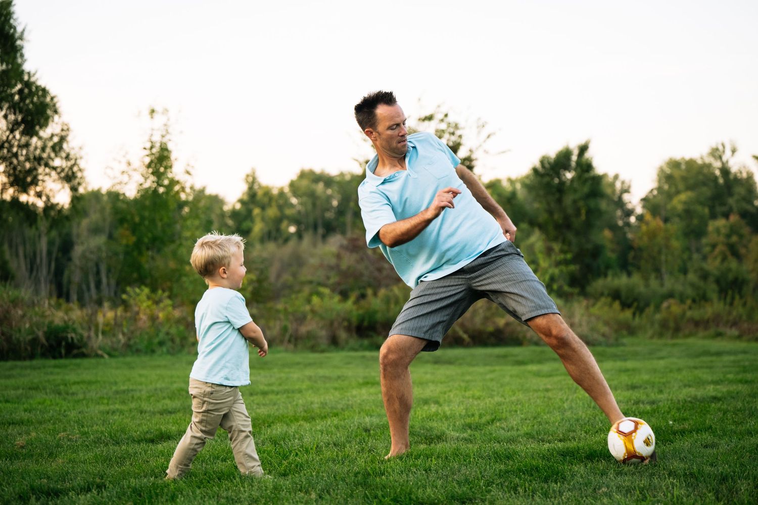 A sequence of action shots showing someone playing soccer in a grassy field at sunset.