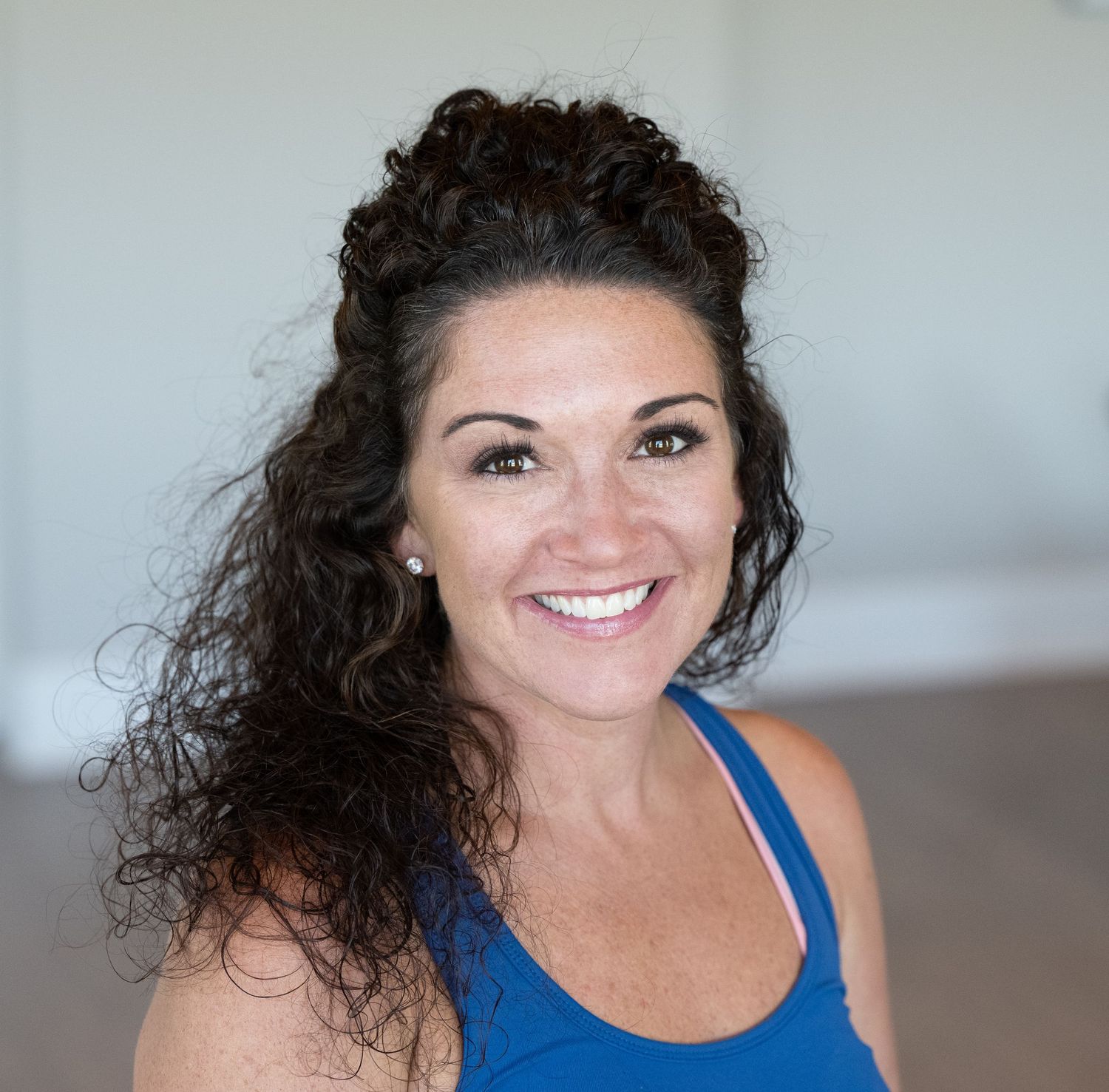 Woman in blue sleeveless top smiling and posing in multiple headshots against light background.