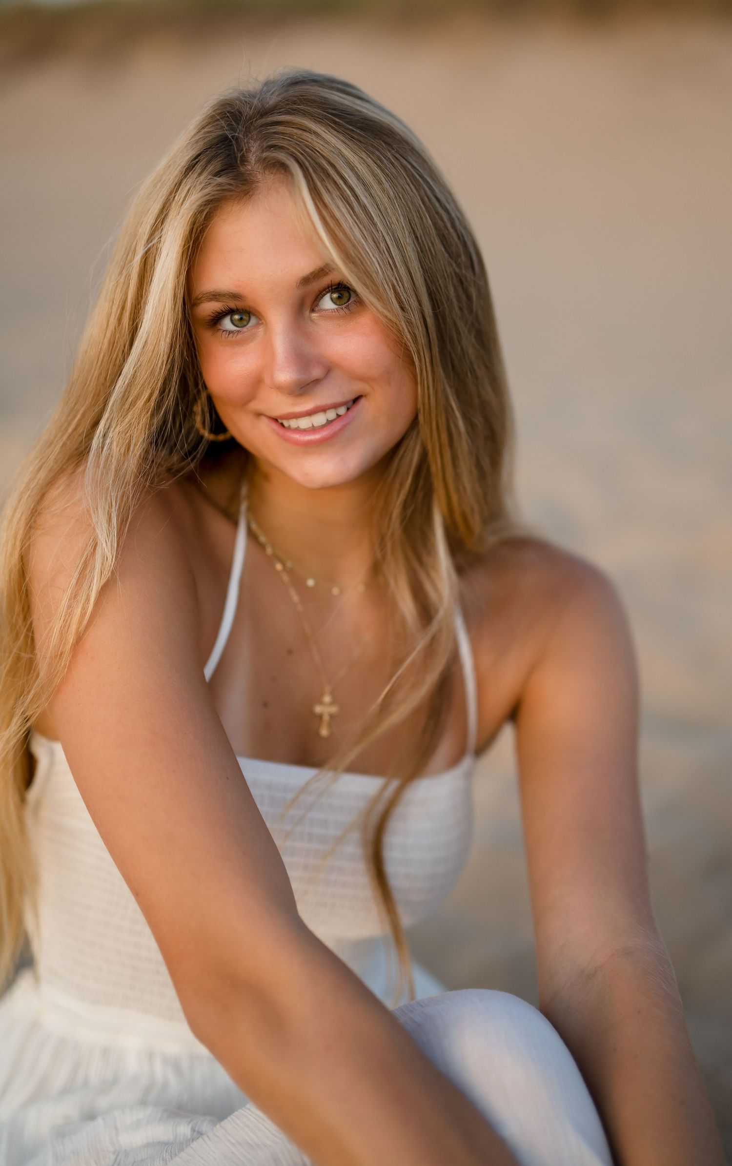 Girl in a white dress for a beach senior portrait session during golden hour on Lake Michigan.