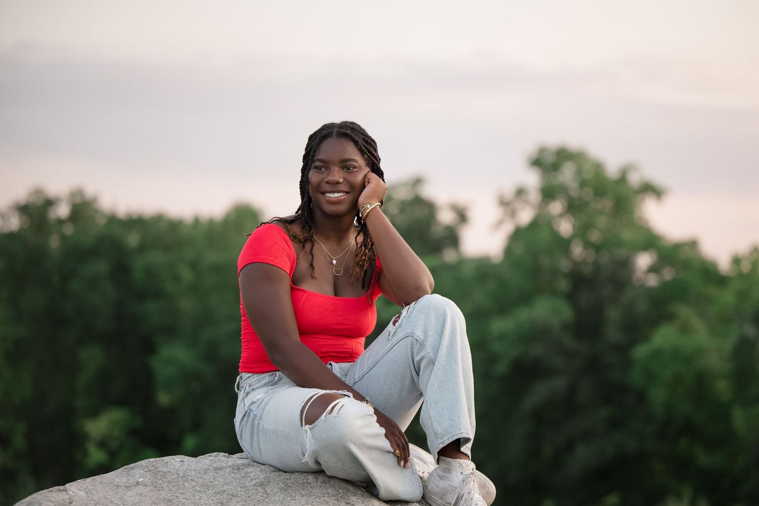 Outdoor portrait session at sunset wearing red top and light denim for senior girl.
