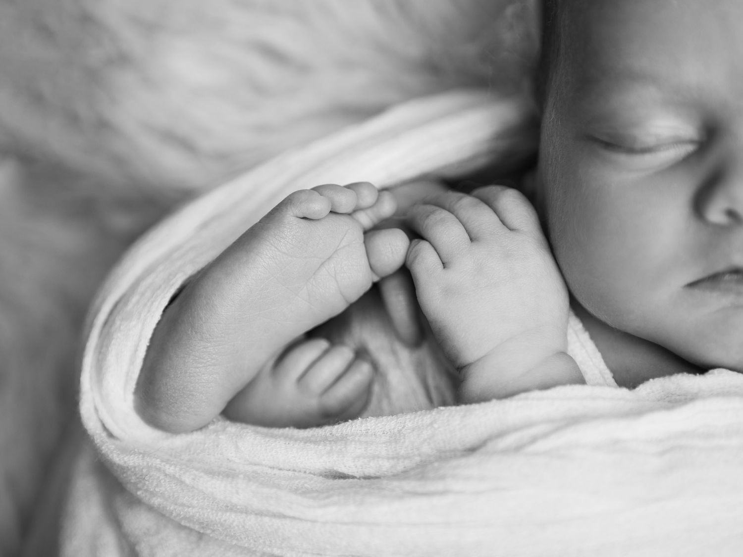 black and white image baby sleeping wrapped in blanket