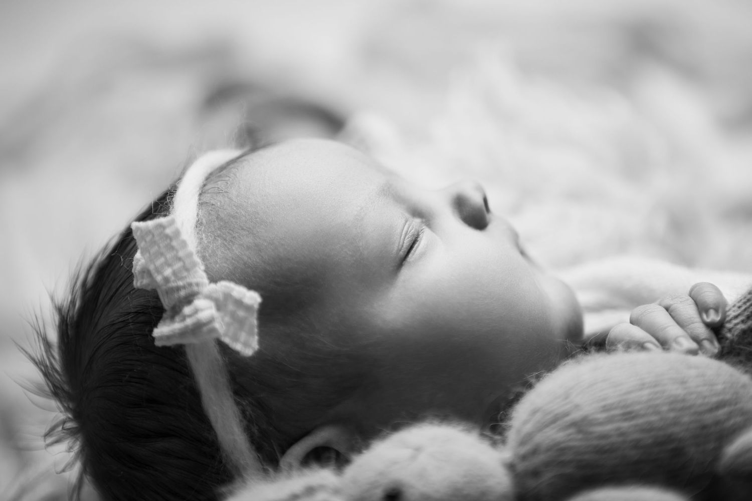 black and white image baby sleeping with headband on