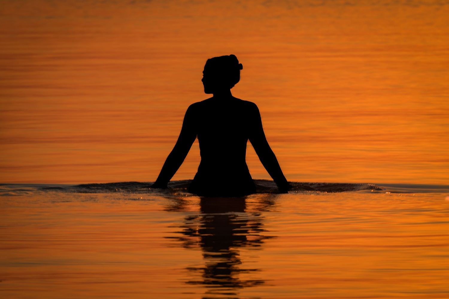 Woman in the sea at sunrise