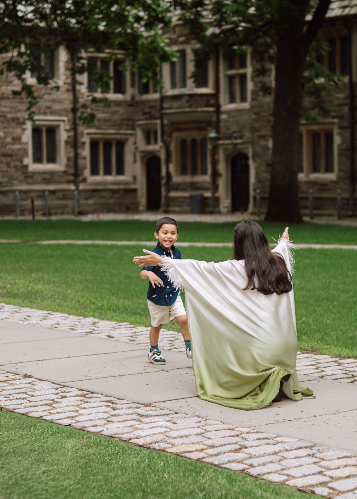 A happy mother and son posing together outdoors amidst the historic collegiate gothic architecture at Princeton University in New Jersey.