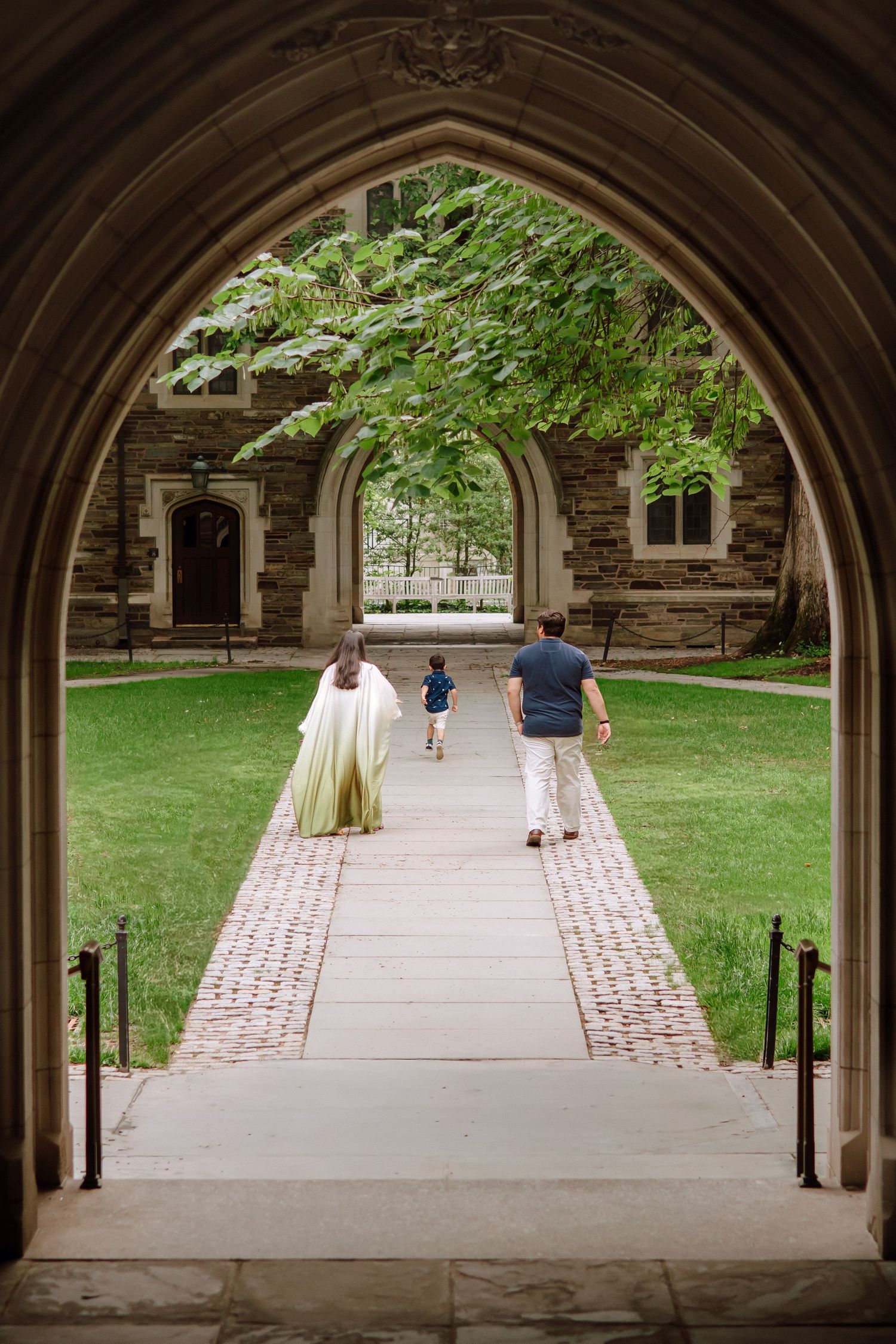 A happy family holding hands and walking together outdoors through the scenic campus grounds at Princeton University in New Jersey.