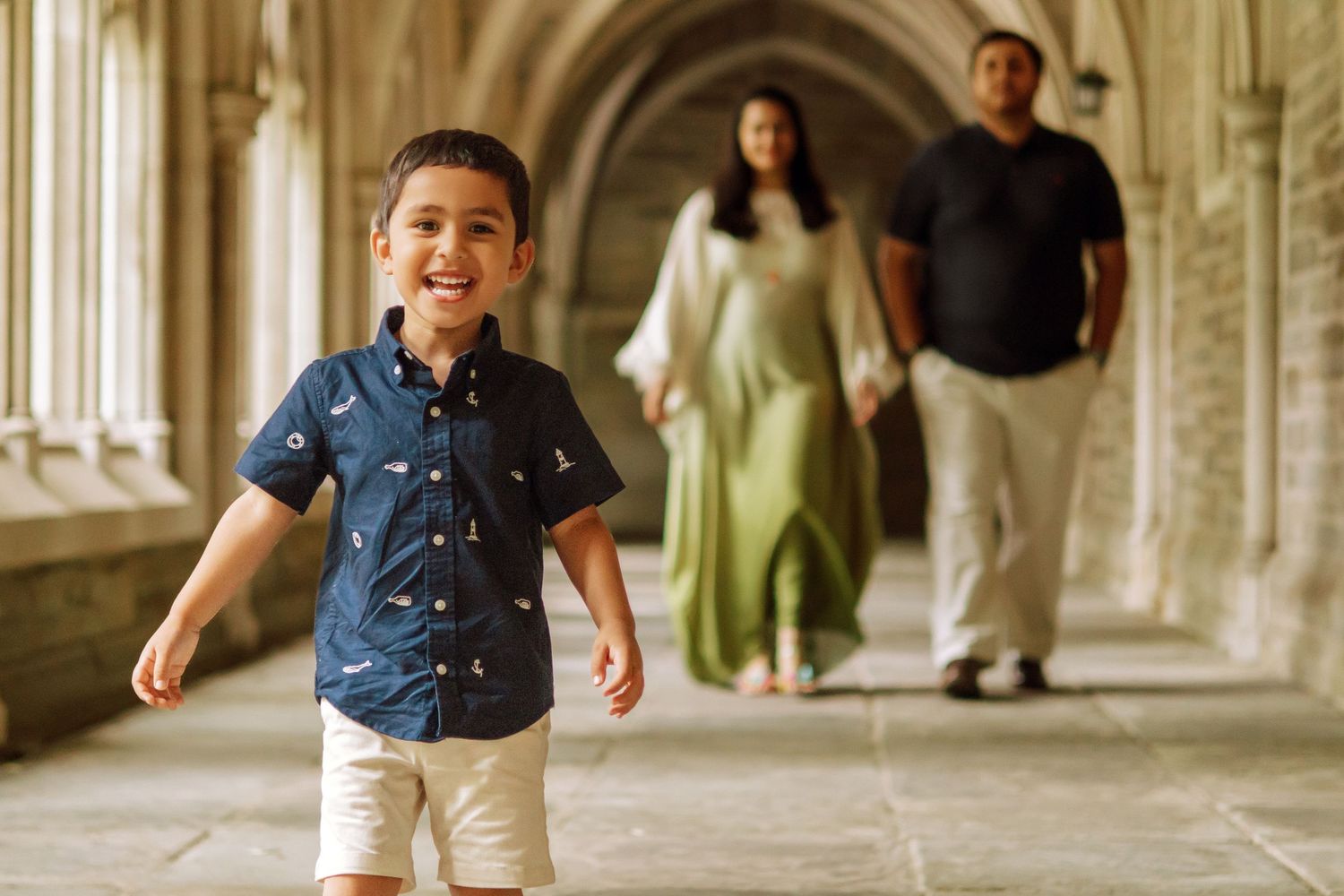 A happy family holding hands and walking together outdoors through the scenic campus grounds at Princeton University in New Jersey.