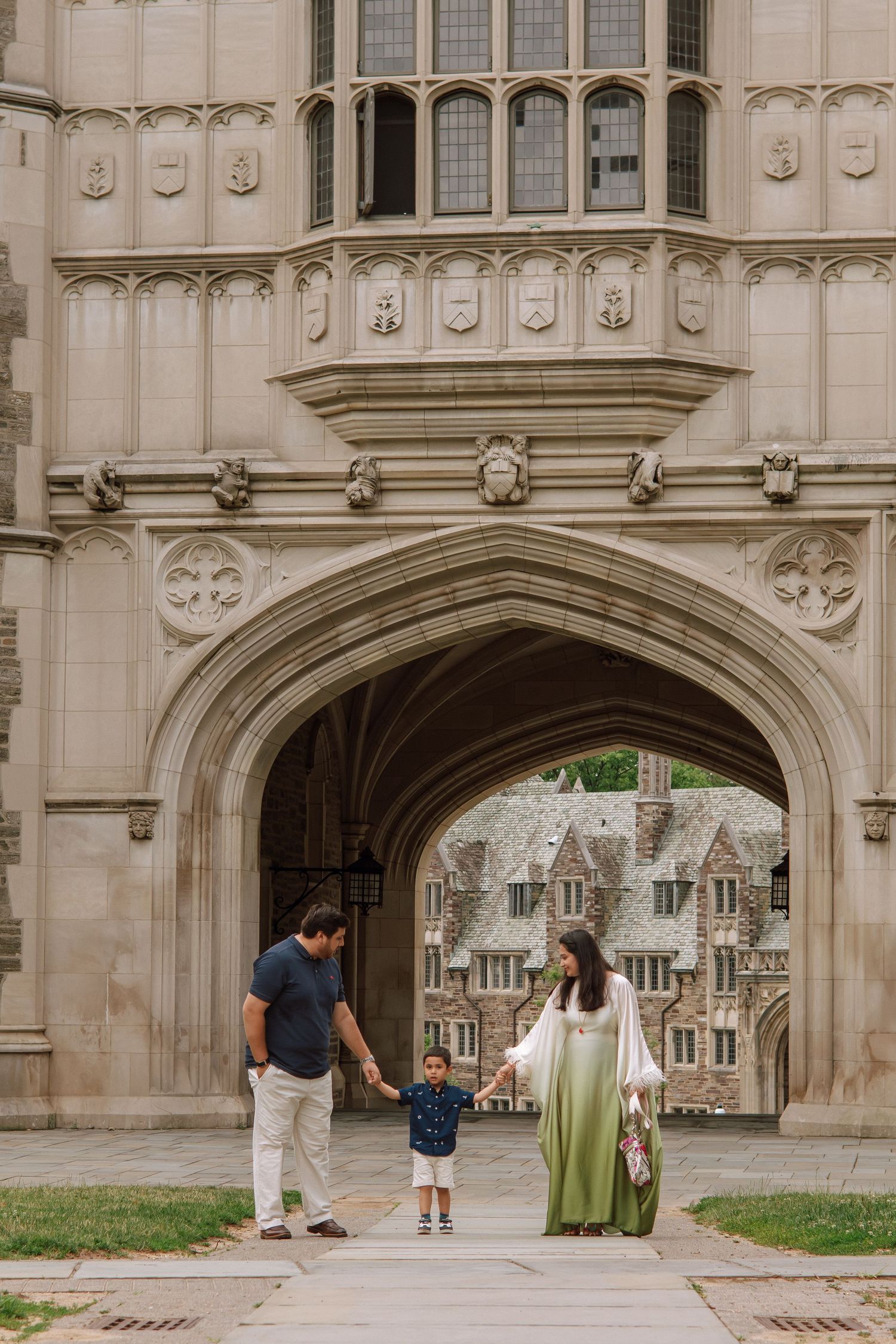 A happy family holding hands and walking together outdoors through the scenic campus grounds at Princeton University in New Jersey.