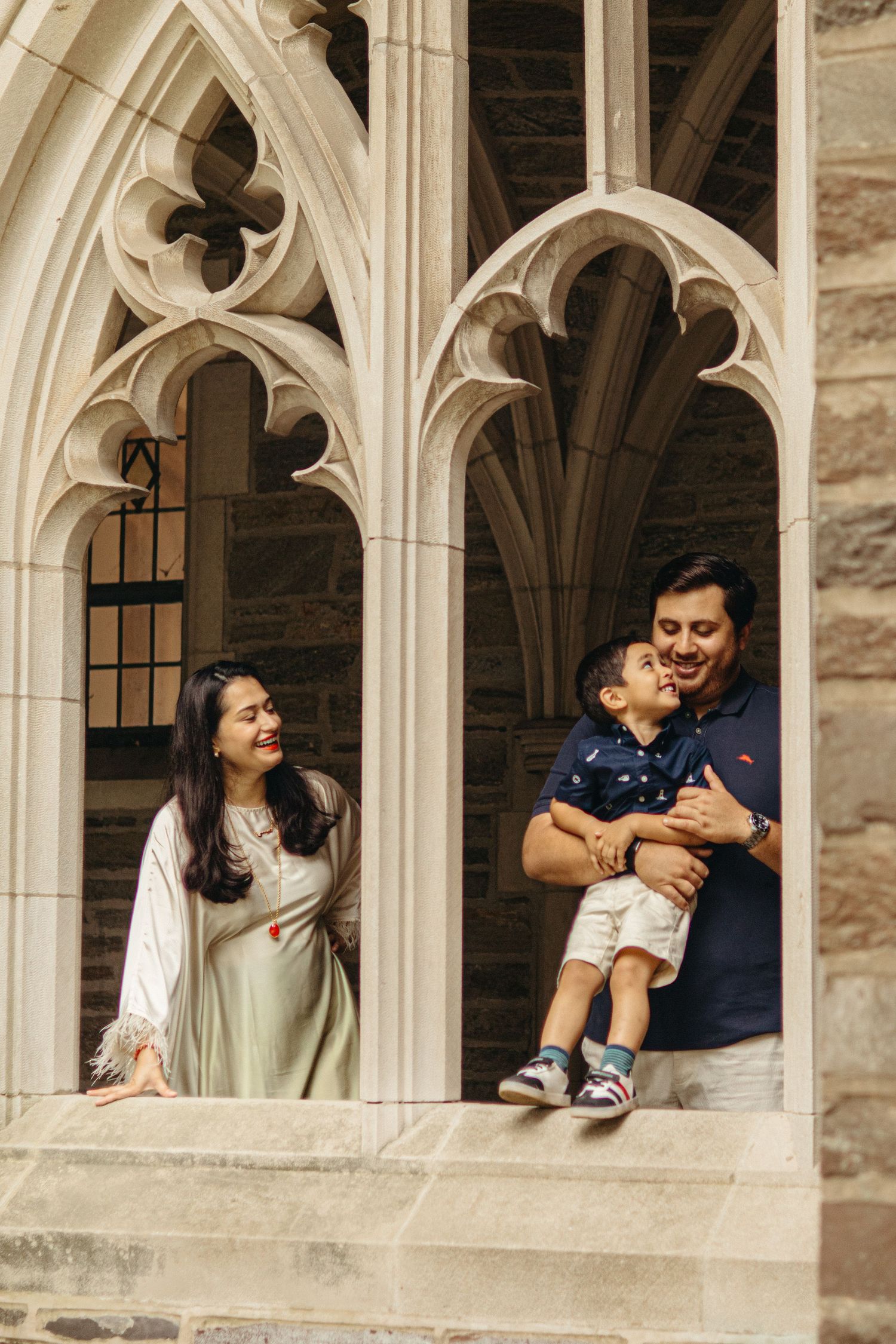 A happy family holding hands and walking together outdoors through the scenic campus grounds at Princeton University in New Jersey.