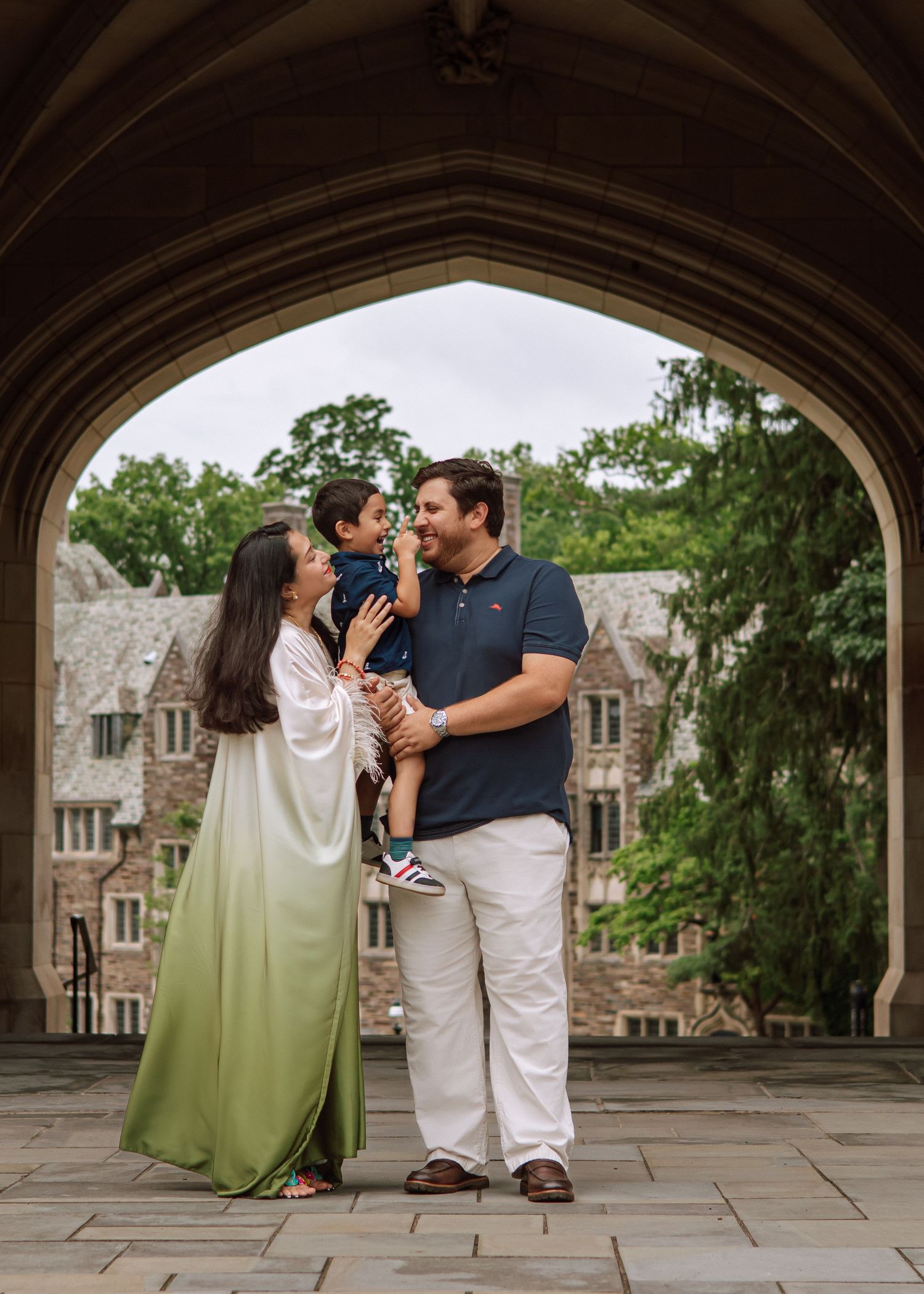 A happy family holding hands and walking together outdoors through the scenic campus grounds at Princeton University in New Jersey.
