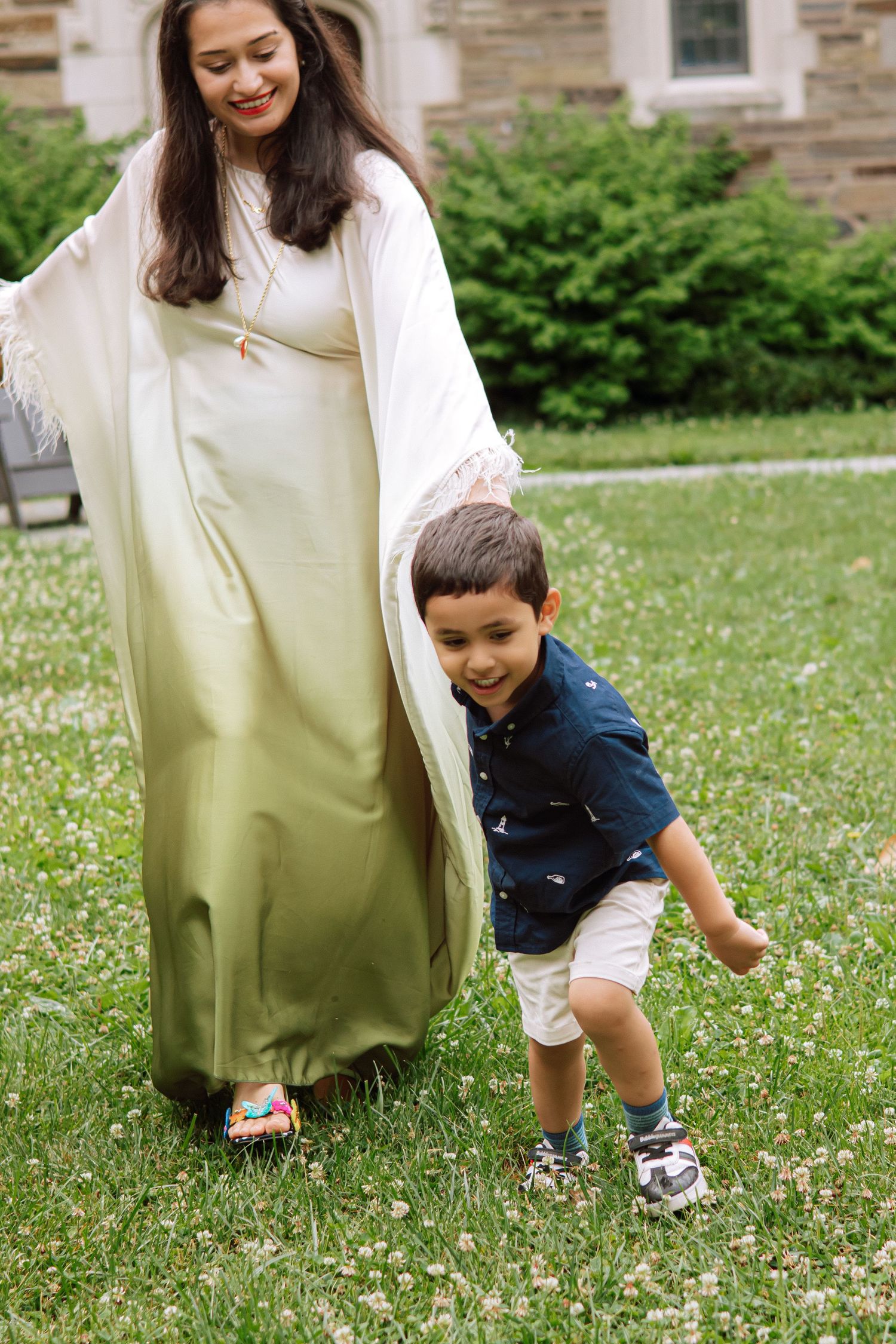 A happy family holding hands and walking together outdoors through the scenic campus grounds at Princeton University in New Jersey.