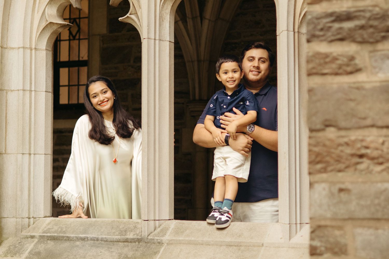 A happy family holding hands and walking together outdoors through the scenic campus grounds at Princeton University in New Jersey.